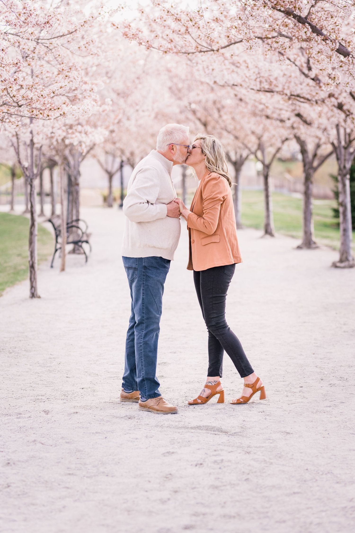 Couple kisses under the blossoms at the Capitol blossoms by Utah engagement photographer Coley Cook