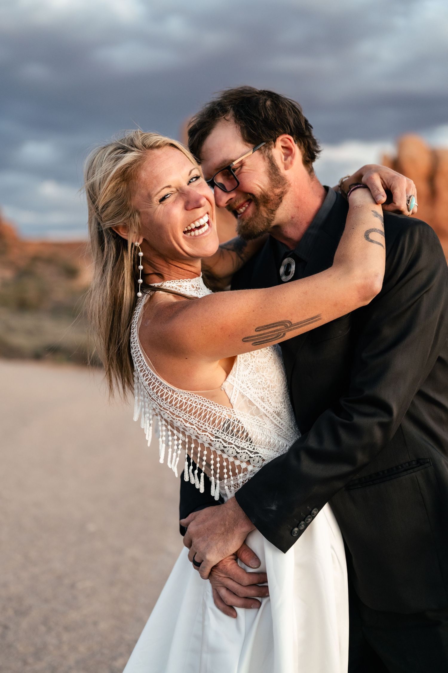 Elopement couple laughs during their wedding photos session in Arches National Park