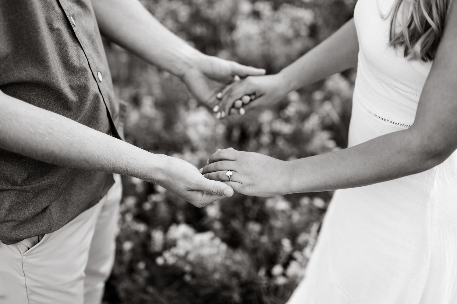 Black and white photo of a couple holding hands, showcasing an engagement ring. Park City mountain location inspo for a surprise proposal.
