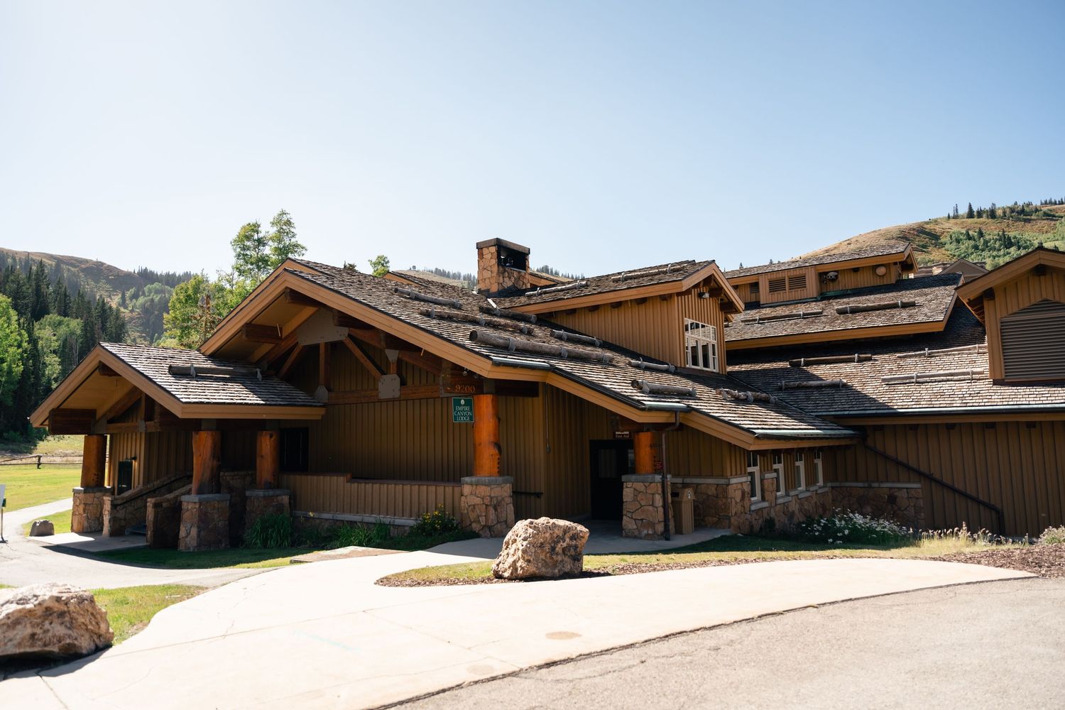 Panoramic view of a luxury mountain lodge exterior with natural wood and stone architecture.