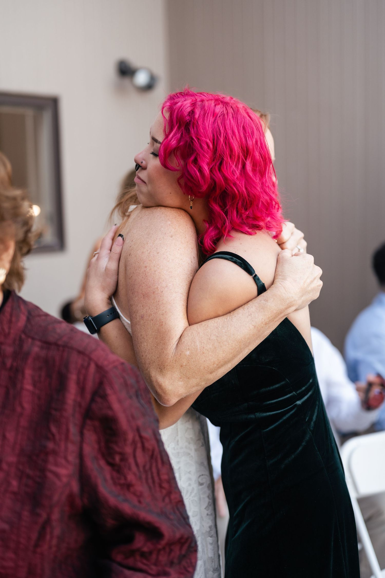 Two people embrace in an emotional moment during a special event.