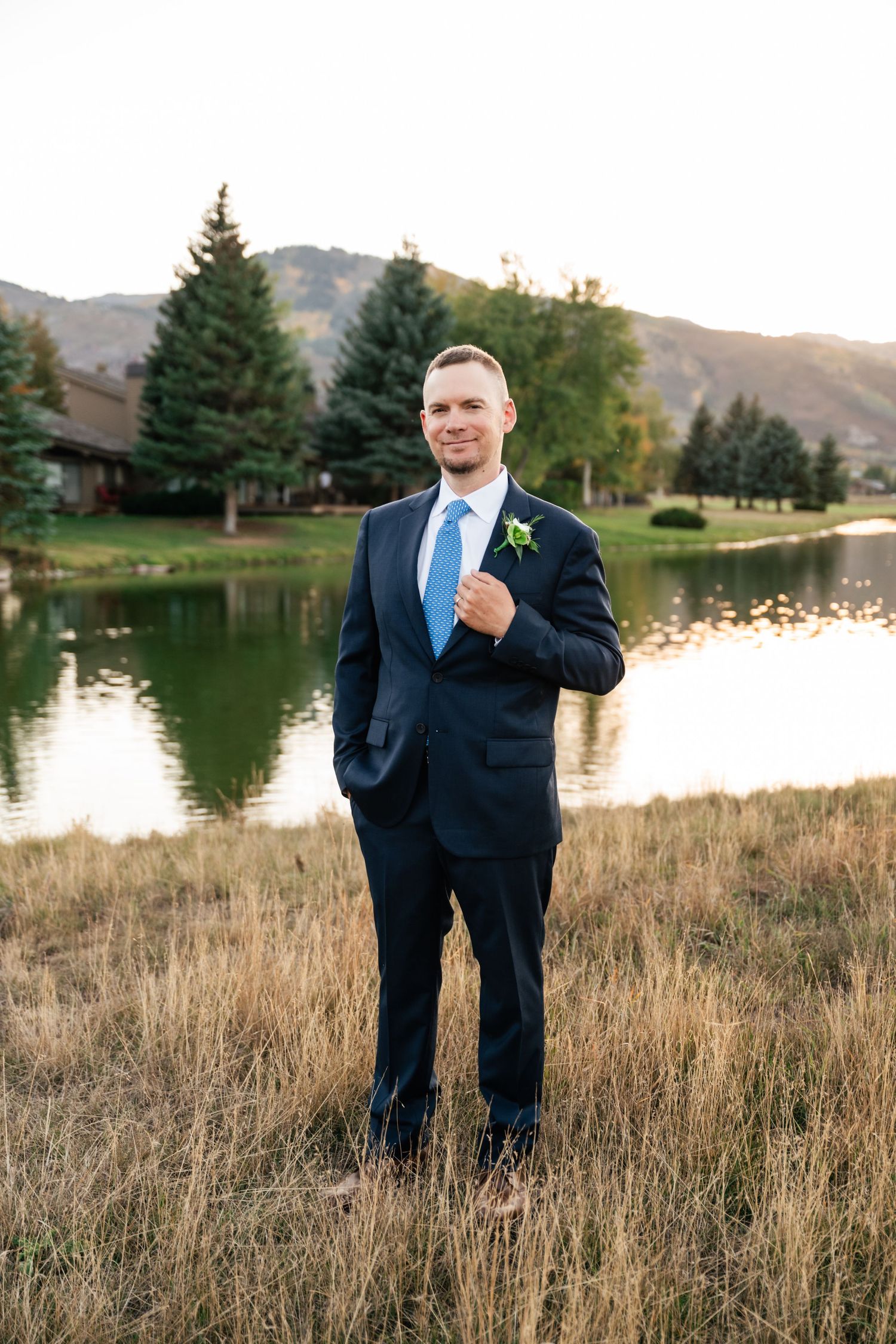 Wedding photography at a lakeside location with mountains and autumn foliage in the background.