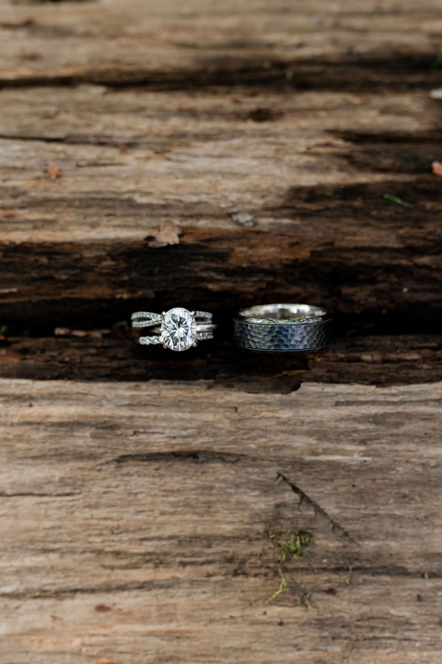 Wedding rings arranged on rustic wooden surface showing intricate details and textures.