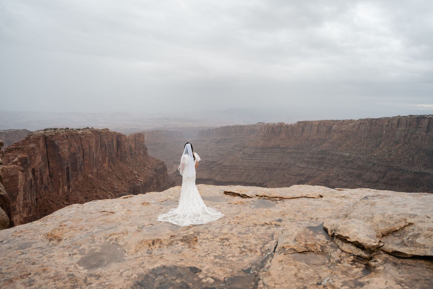 Dramatic cliffside overlook with sweeping views of red rock canyons and desert landscape.