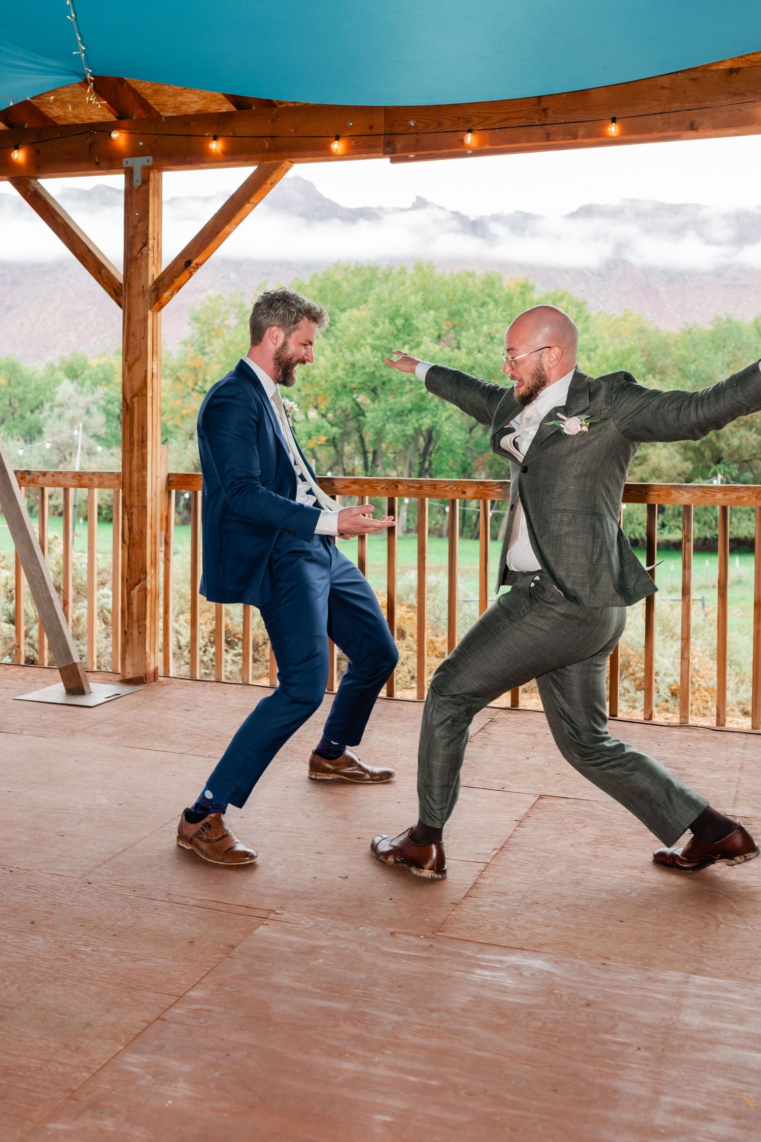 Wedding guests perform a choreographed dance routine on a rustic covered patio.
