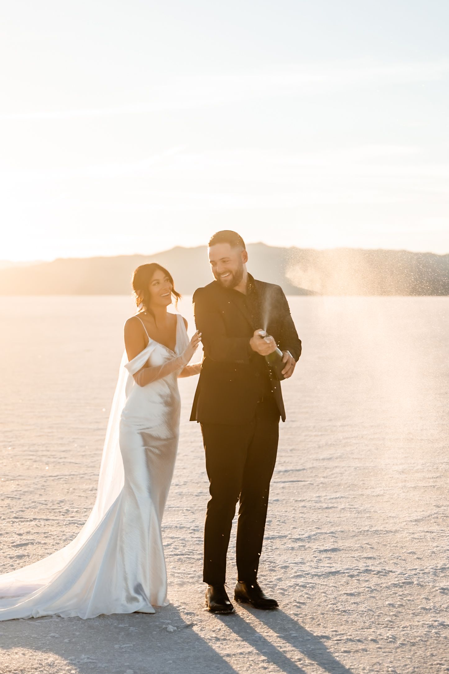Couple shares intimate moment during sunset photoshoot on salt flats.