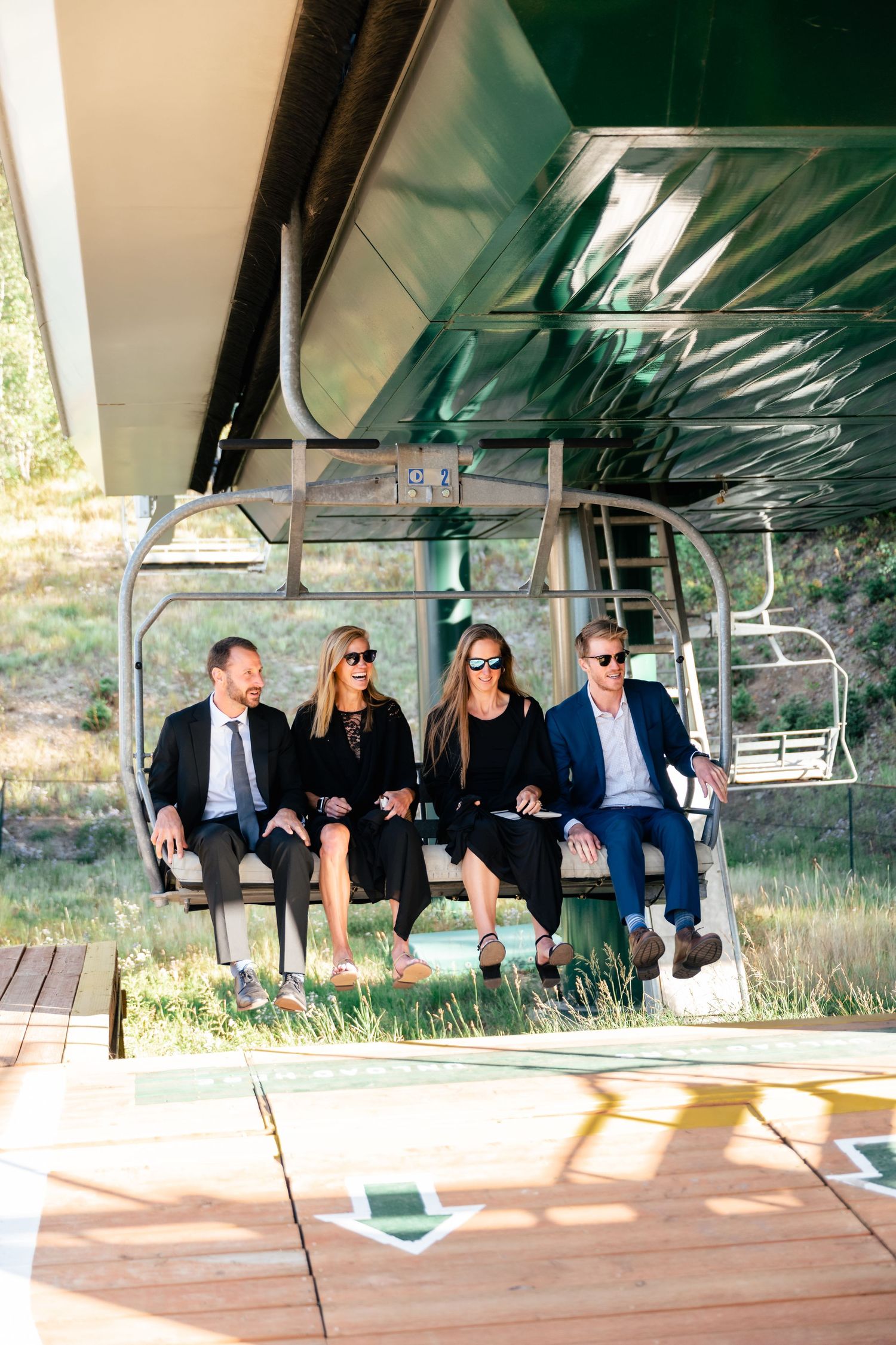 Wedding guests seated on a covered platform overlooking a scenic mountain landscape.