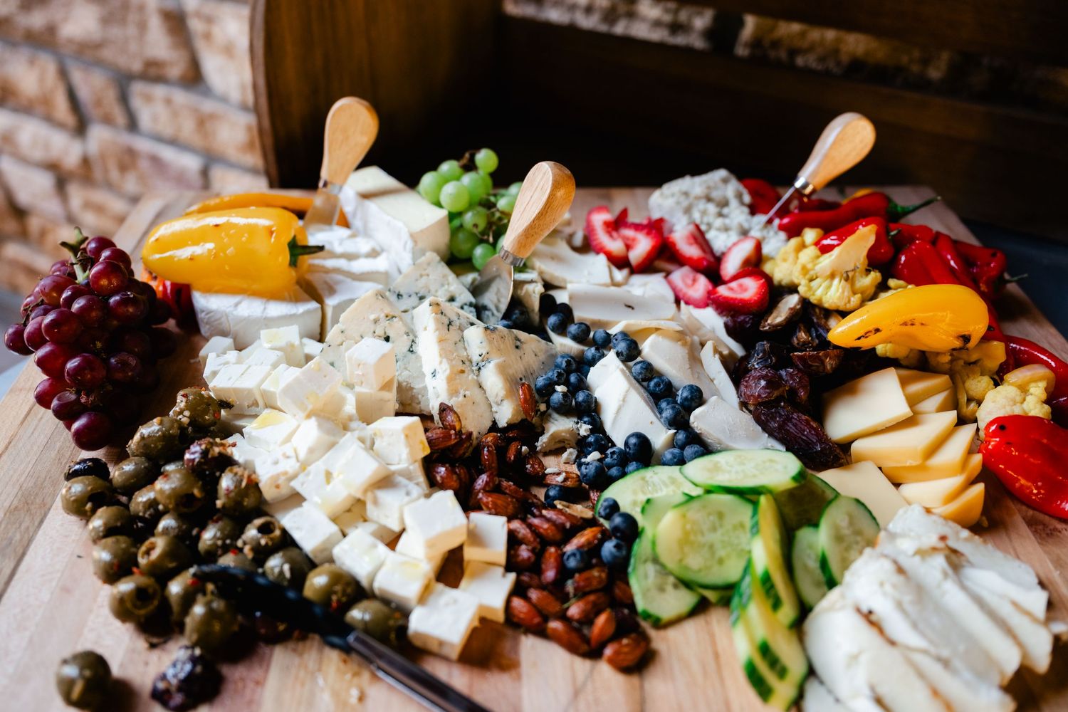 Gourmet cheese and charcuterie board with assorted meats, fruits, nuts and garnishes.