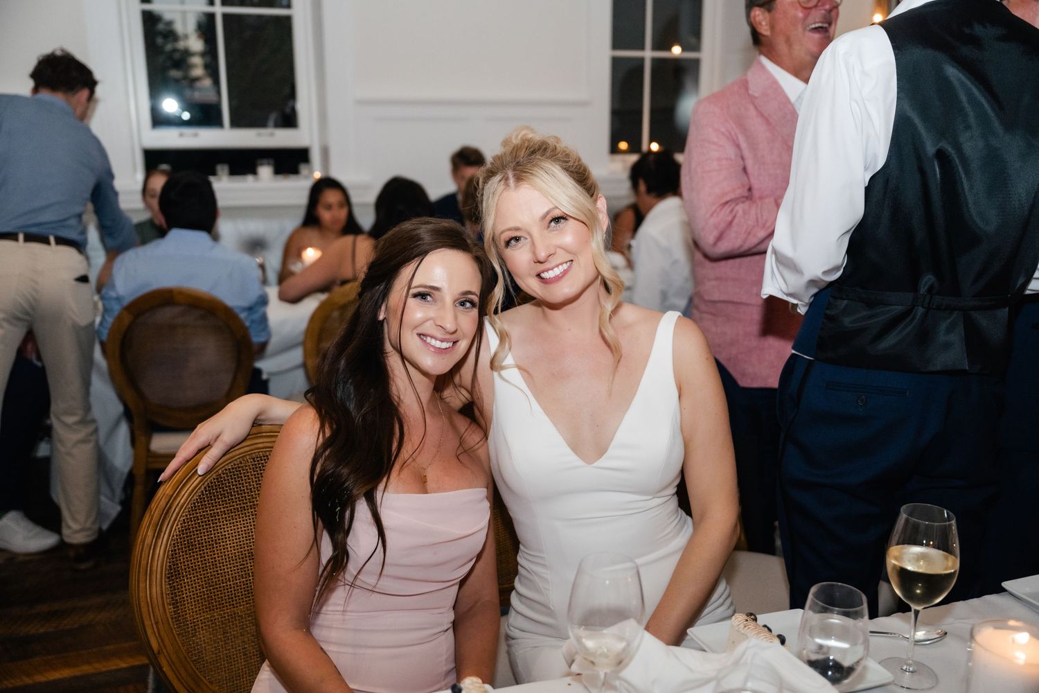 Wedding guests enjoying conversation and drinks at an elegant indoor reception.