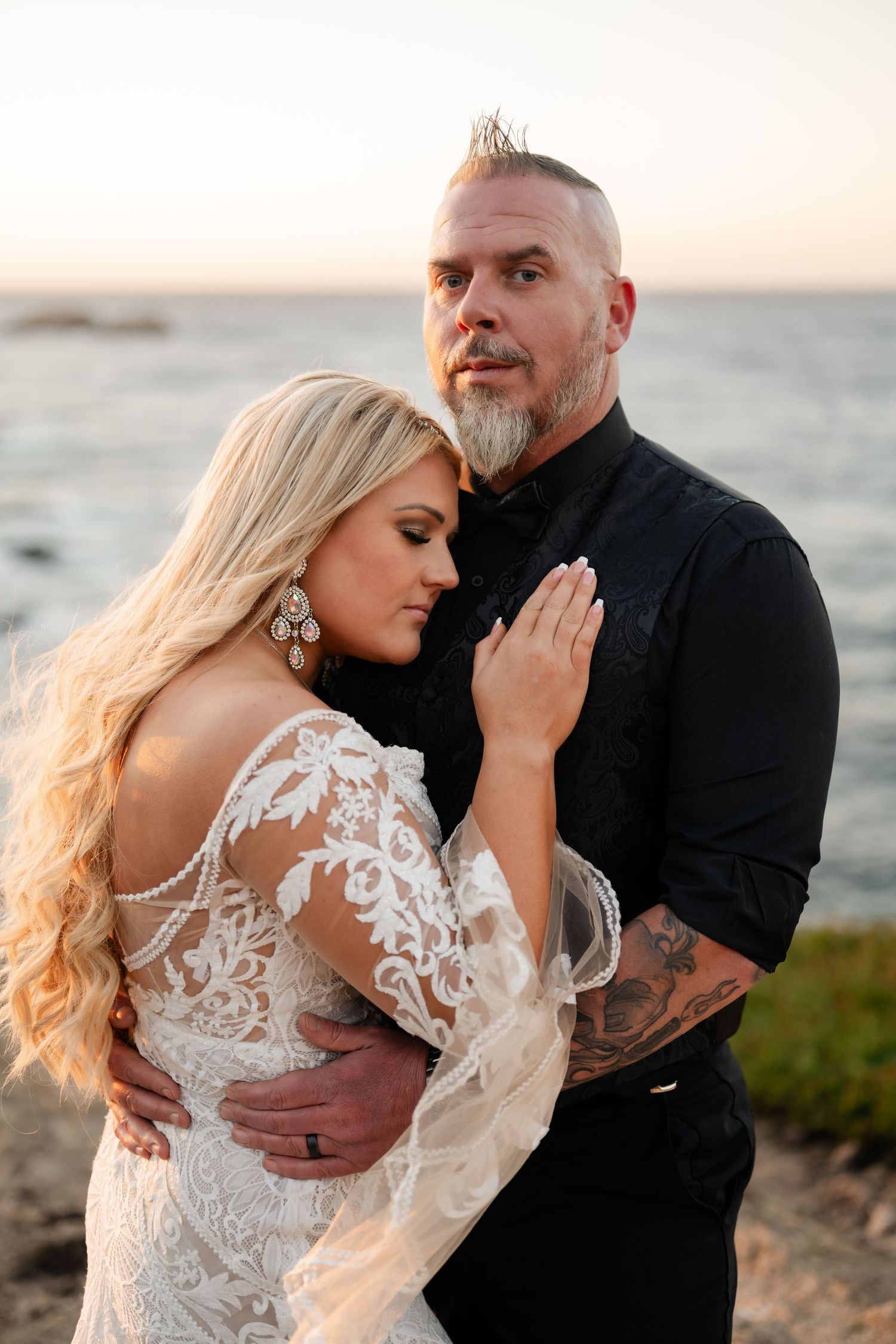Intimate coastal sunset portrait showing romantic embrace against ocean backdrop.