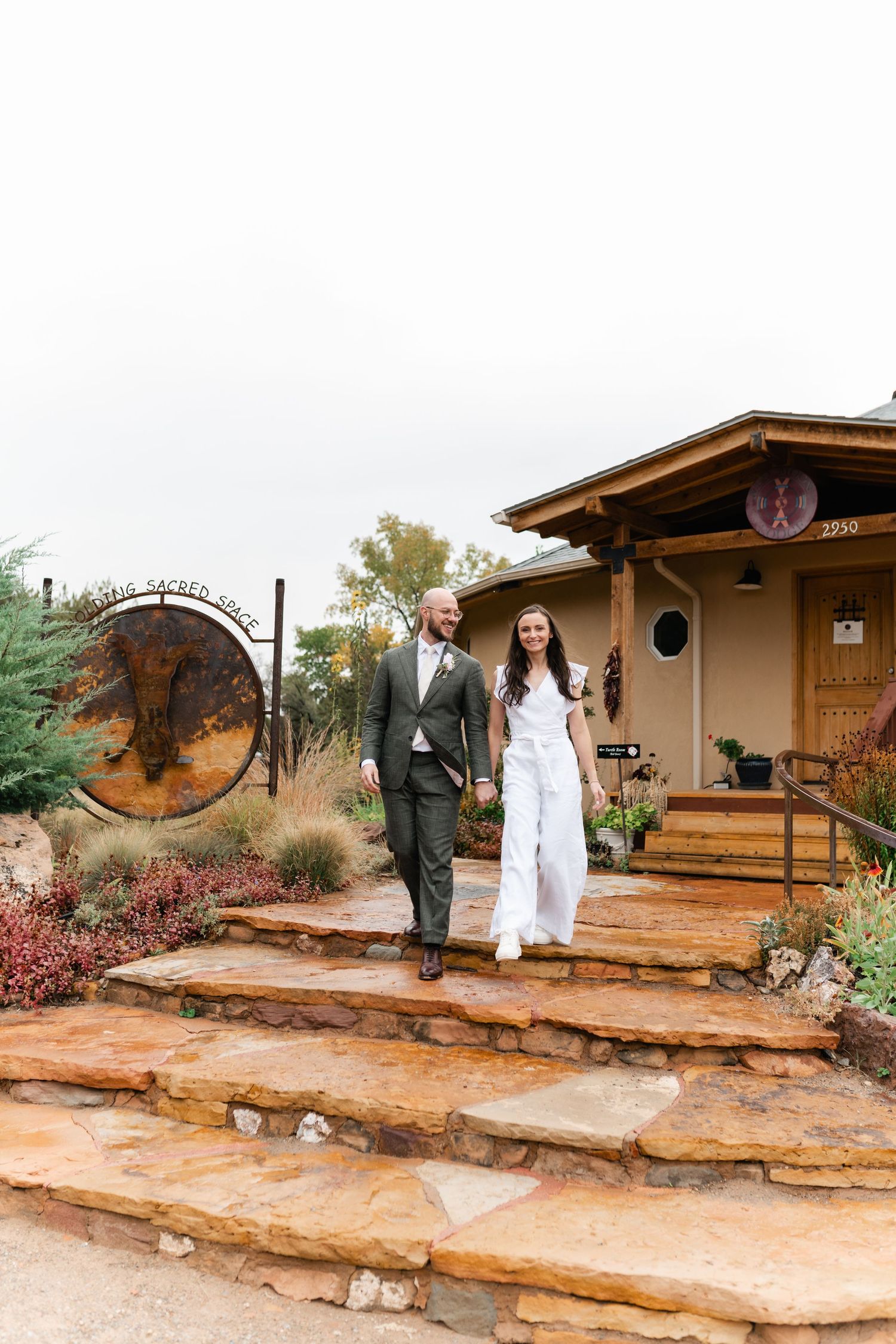 A series of photos showing two people in contrasting outfits walking along rustic stone steps outside adobe-style buildings.