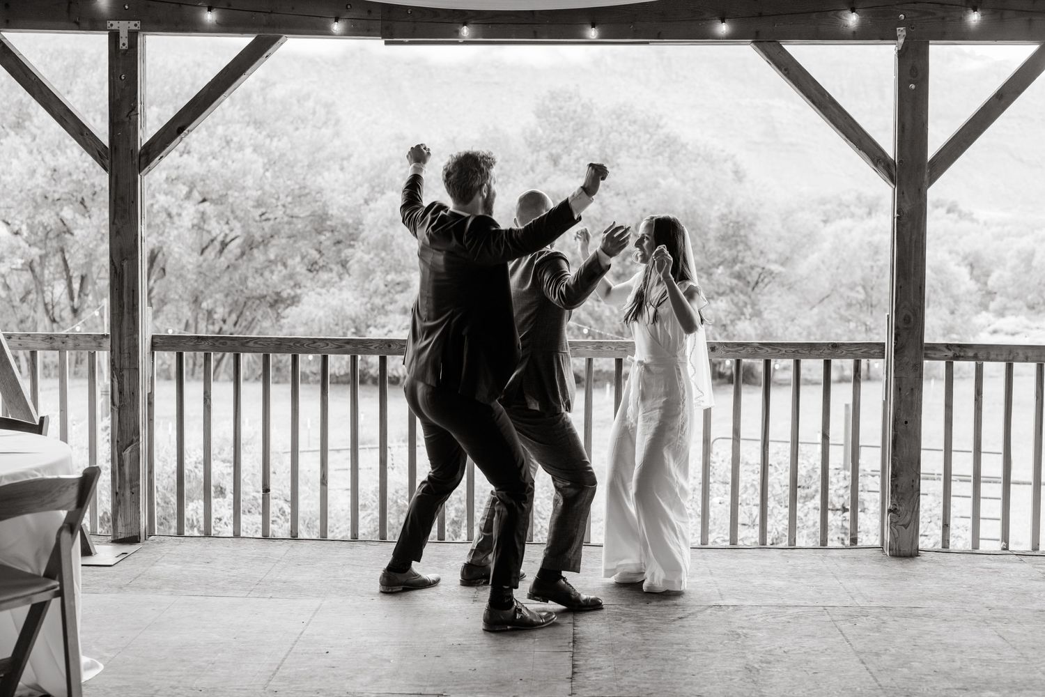 Black and white photo of wedding dance sequence in covered outdoor pavilion.