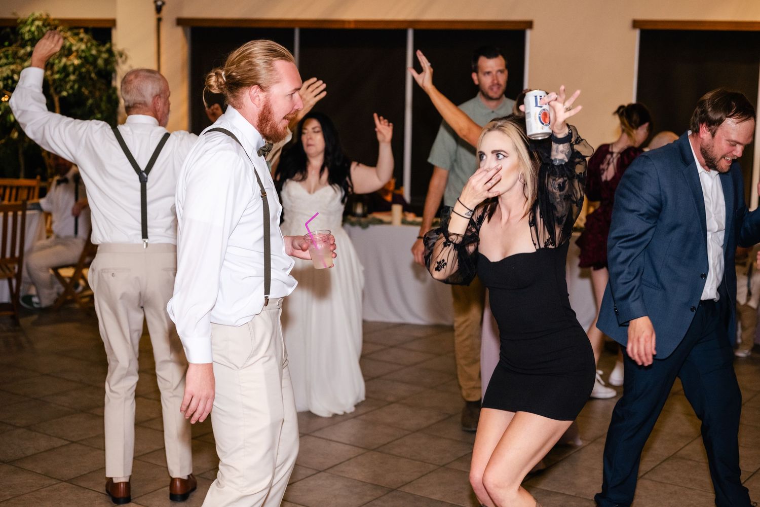 Wedding guests dance and celebrate on the dance floor during the reception party.