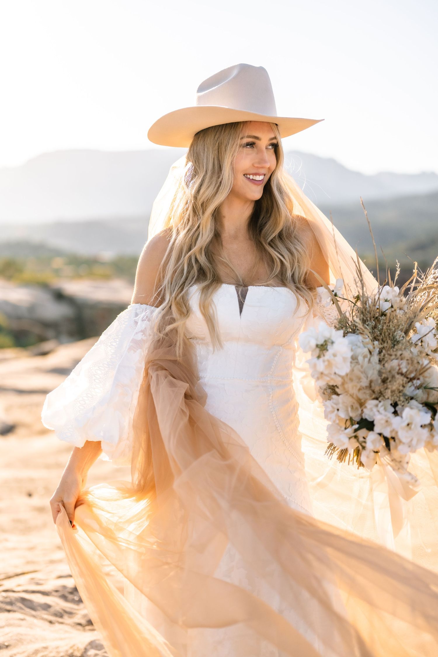 Utah elopement photographer takes breathtaking desert sunrise bridal session with a stunning bouquet and cowgirl hat.