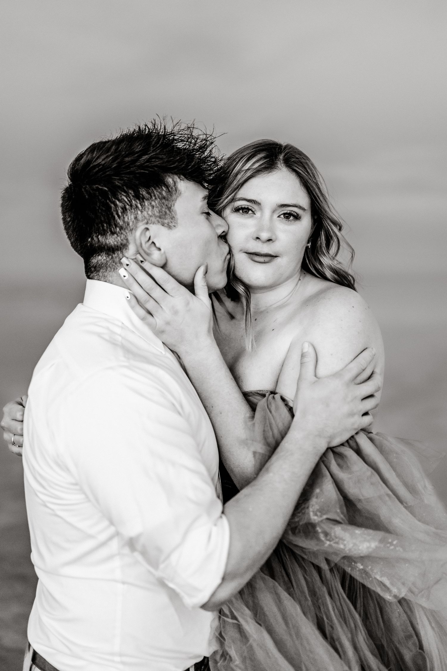 Romantic moment captured as the couple embraces amidst the serene beauty of the flooded Salt Flats during blue hour