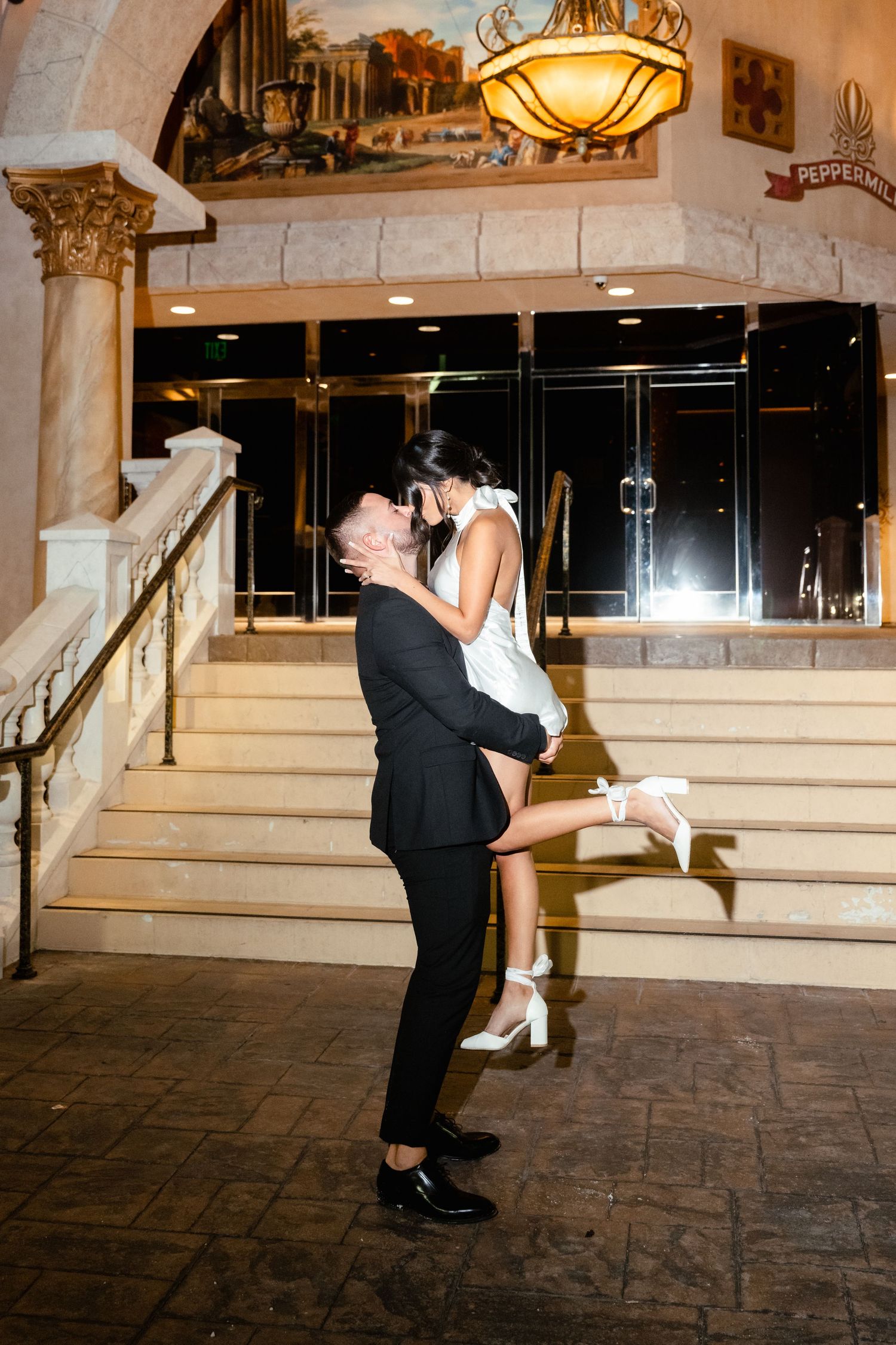 Wedding couple performs romantic dip dance moves under elegant venue lighting.