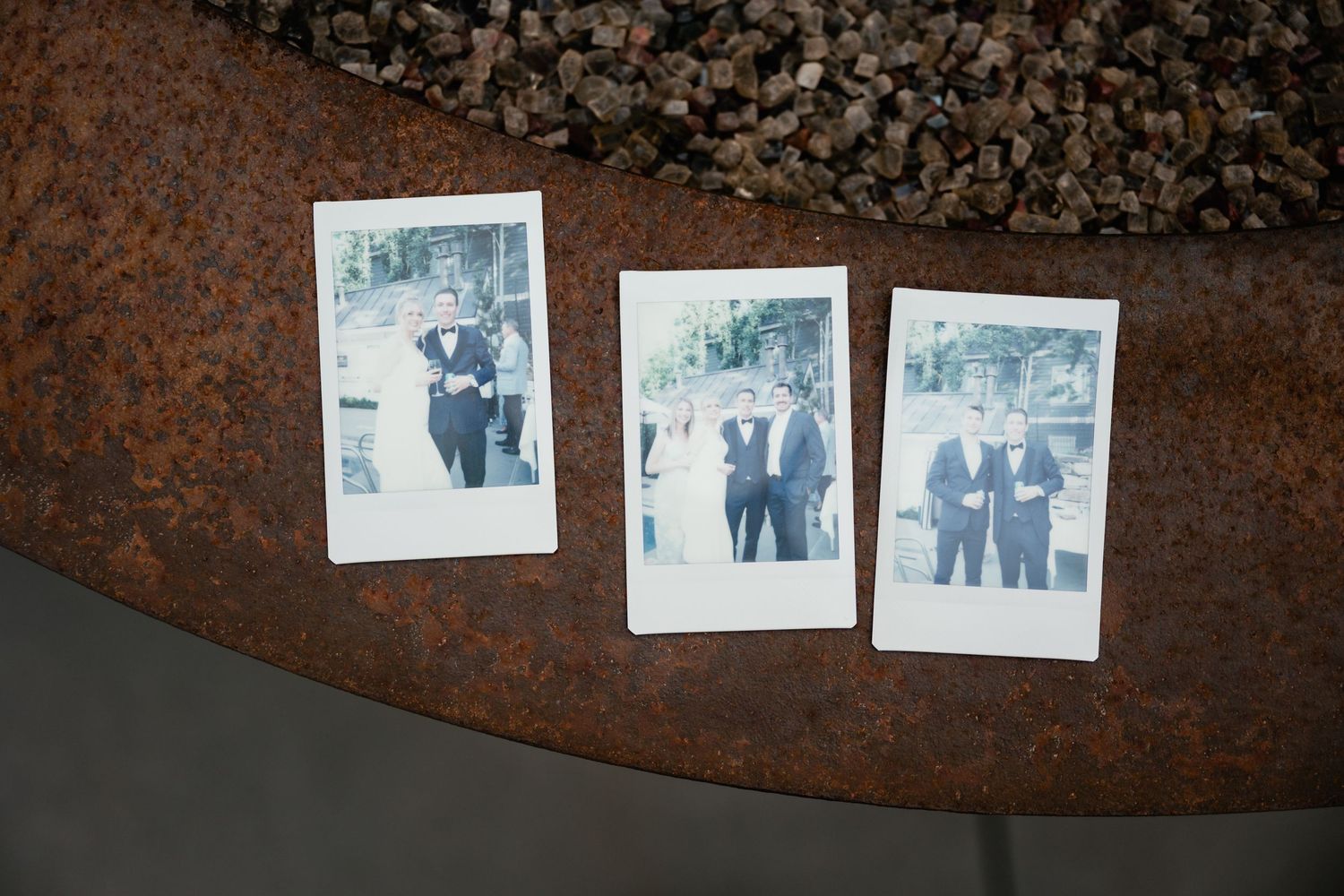 Vintage polaroid photos displayed on rustic metal surface create nostalgic wedding memory display.