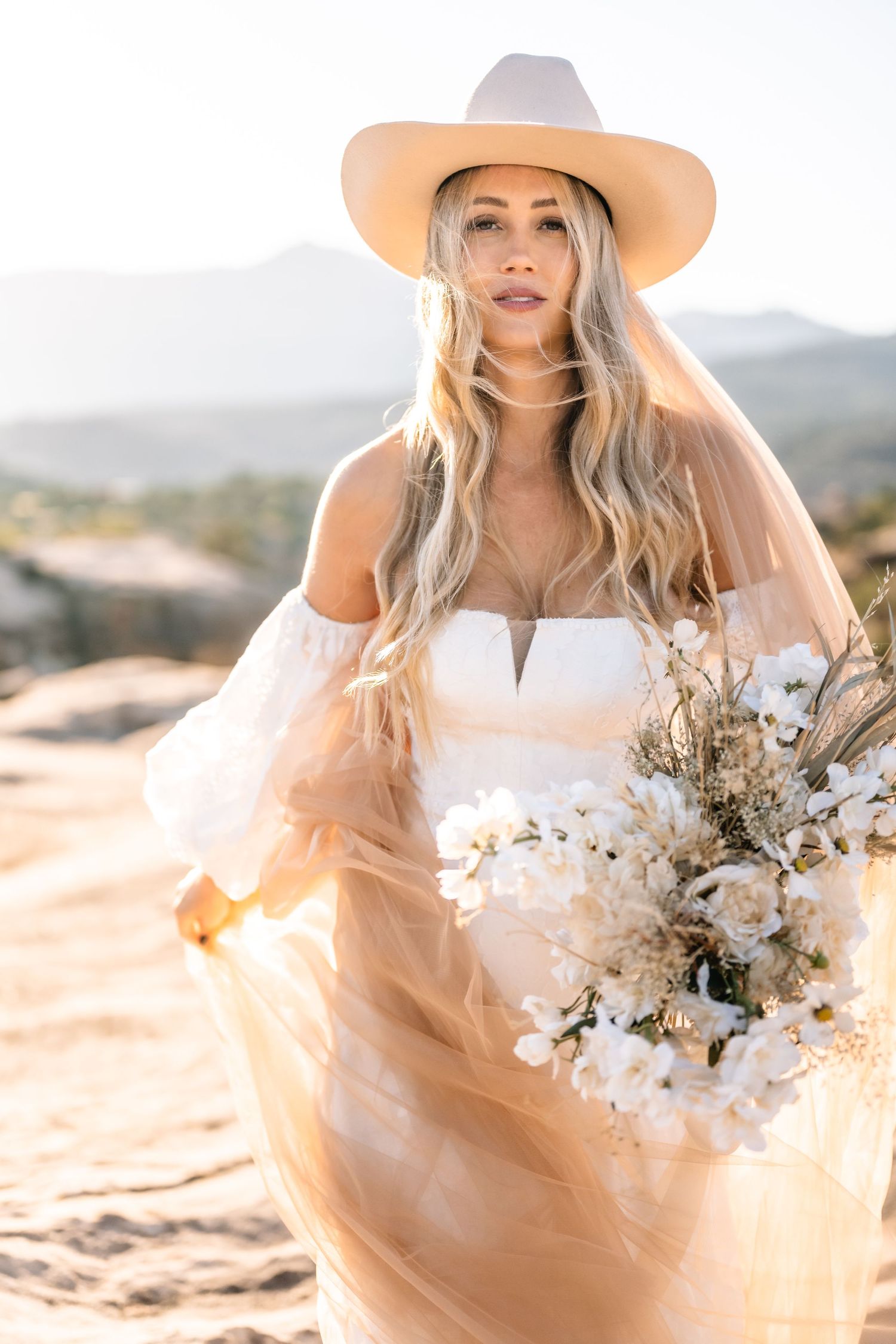 Utah elopement photographer takes breathtaking desert sunrise bridal session with a stunning bouquet and cowgirl hat.