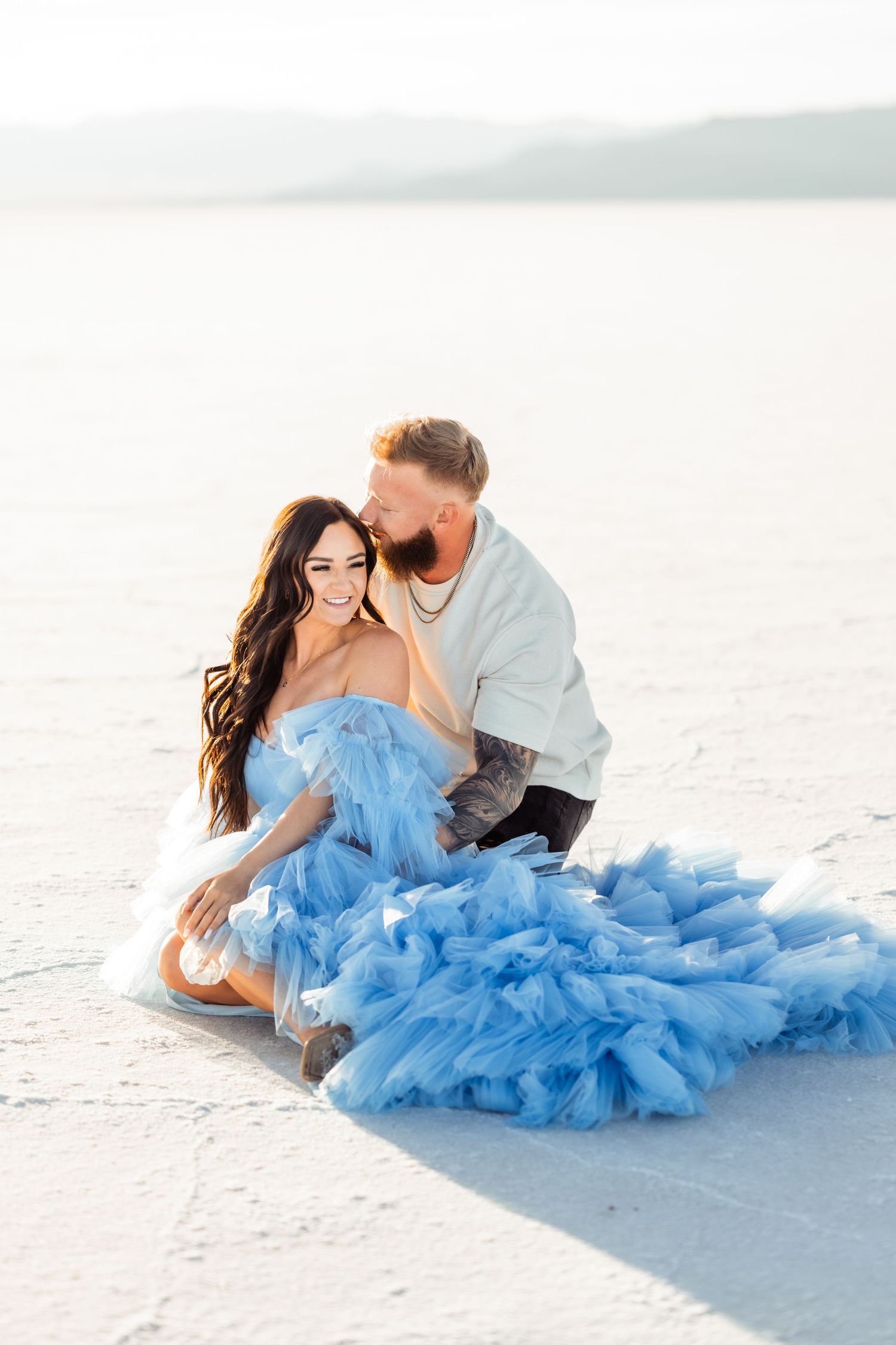 Couple sits together at the Salt Flats by Utah engagement photographer Coley Cook