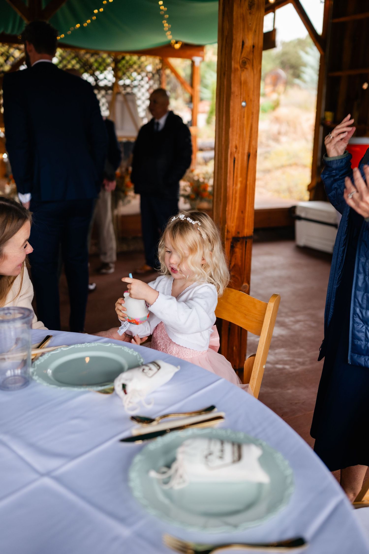 Wedding guests enjoying desserts at an elegantly set table with blue plates and white linens.