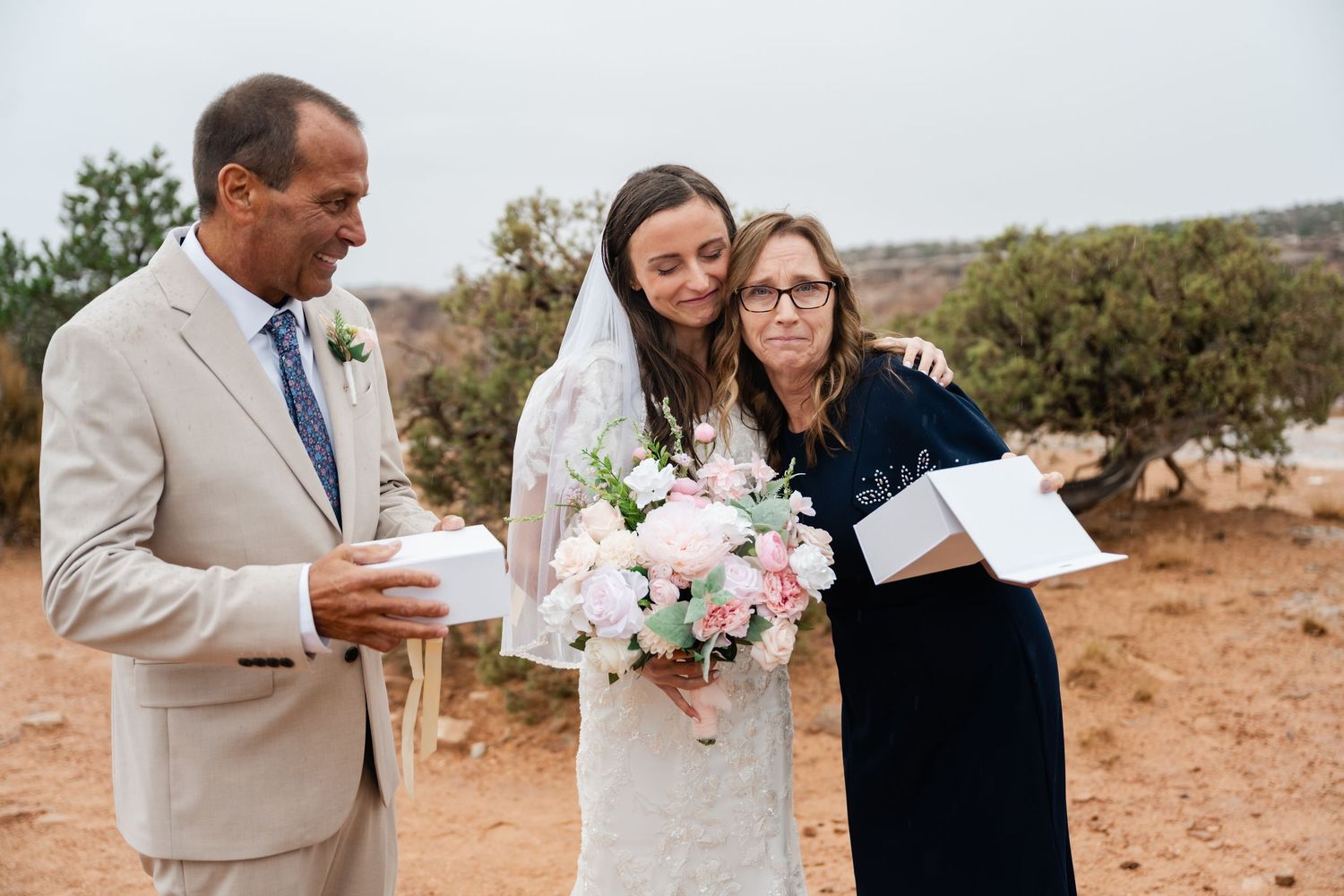 A couple shares intimate moments during their desert wedding ceremony with scenic mountain views in the background.