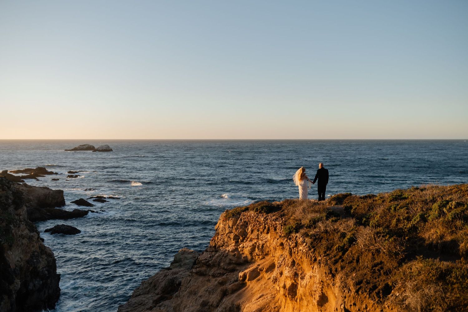 Dramatic coastal cliffs and ocean waves at sunset creating stunning landscape.