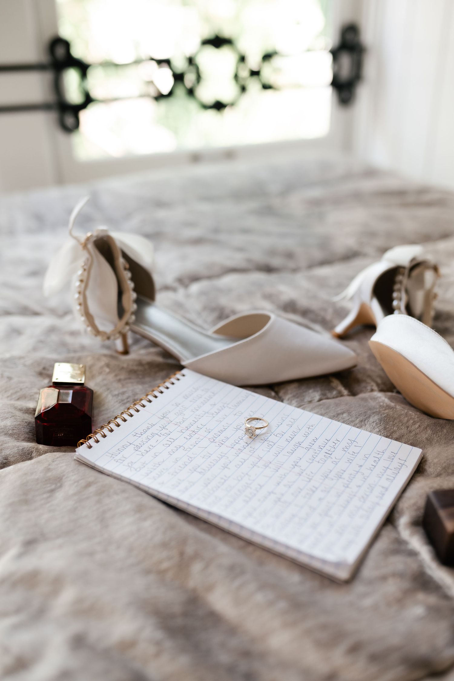 Handwritten wedding vows on white paper with a ring placed beside it.