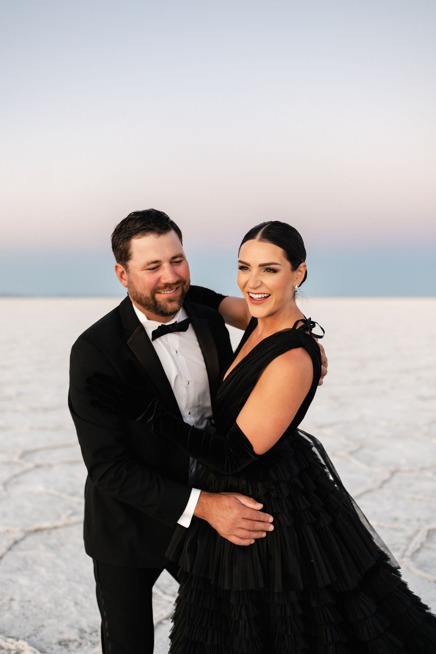 Utah Salt Flats Photographer. A joyful moment captured during a formal photoshoot on bright white salt flats.