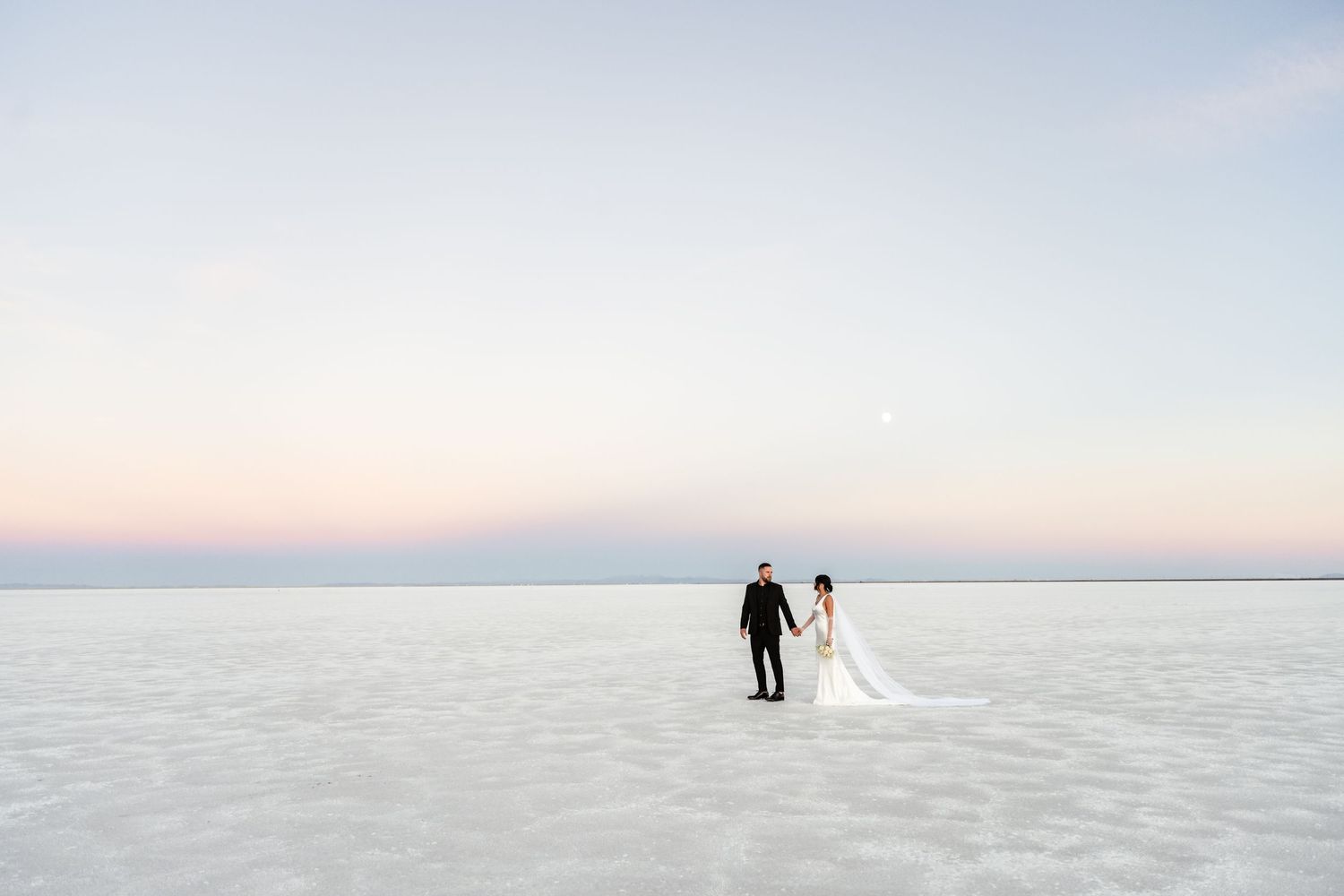Minimalist wedding photos showing silhouettes against the expansive white salt flats at sunset.