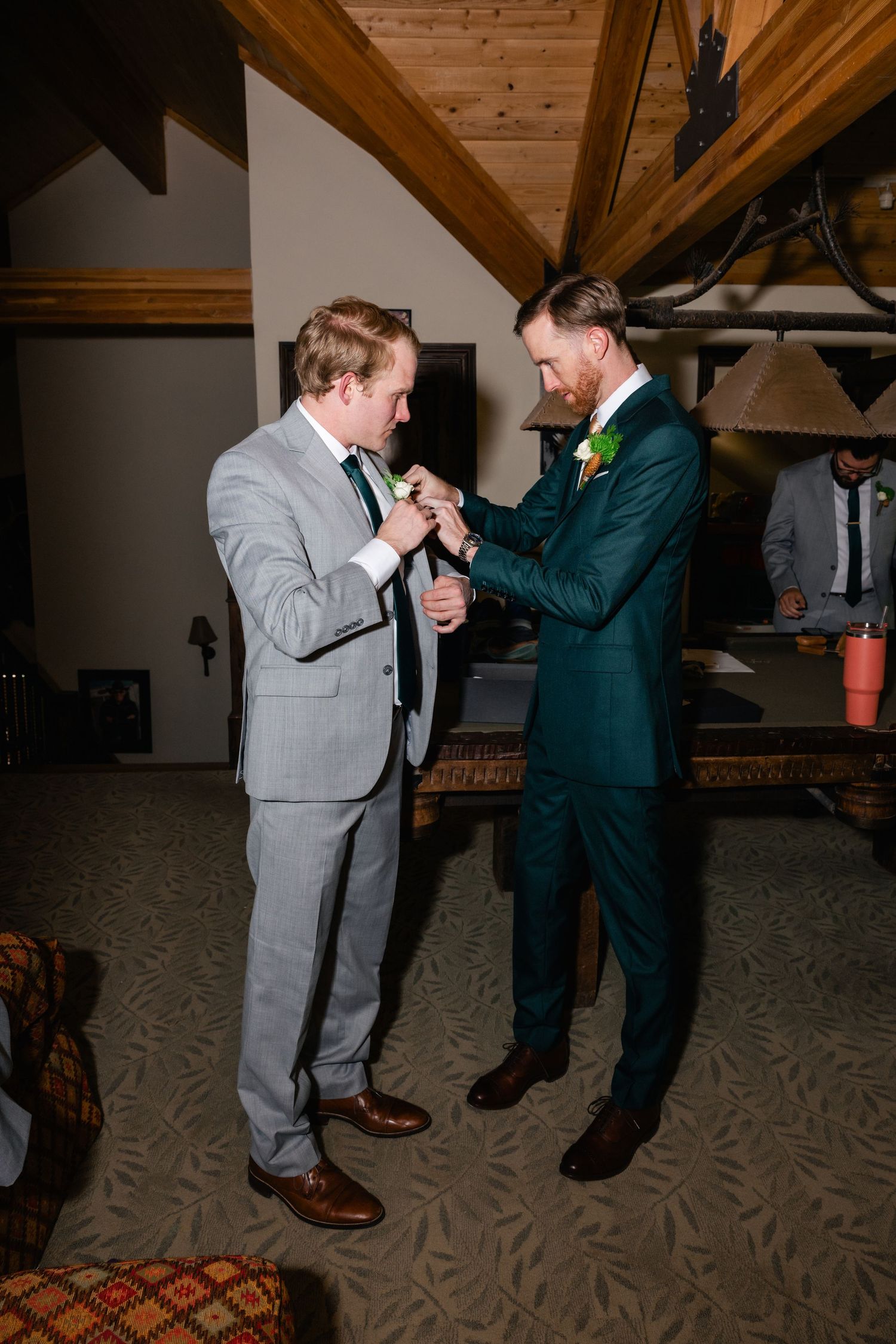 Two people in formal suits sharing an emotional moment indoors.