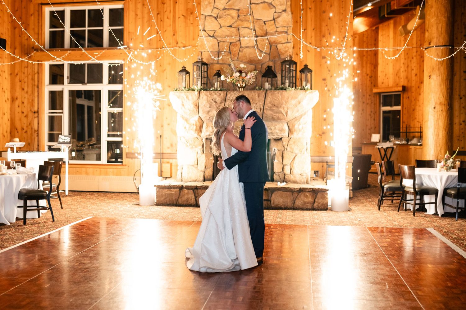Couple dances in an elegant venue with stone walls and warm lighting.