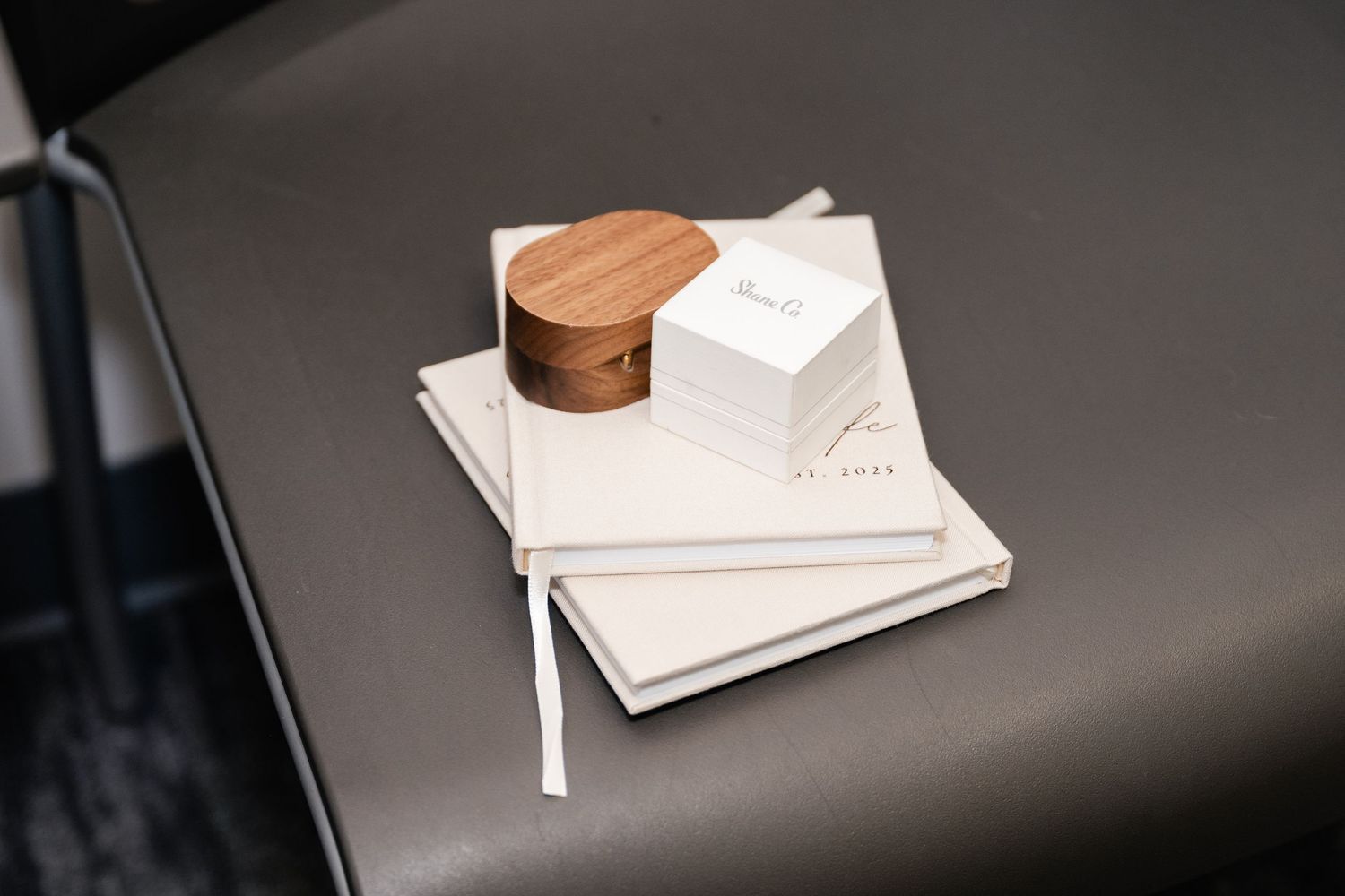 Person signing important documents on a desk with a wooden pen holder and white papers.