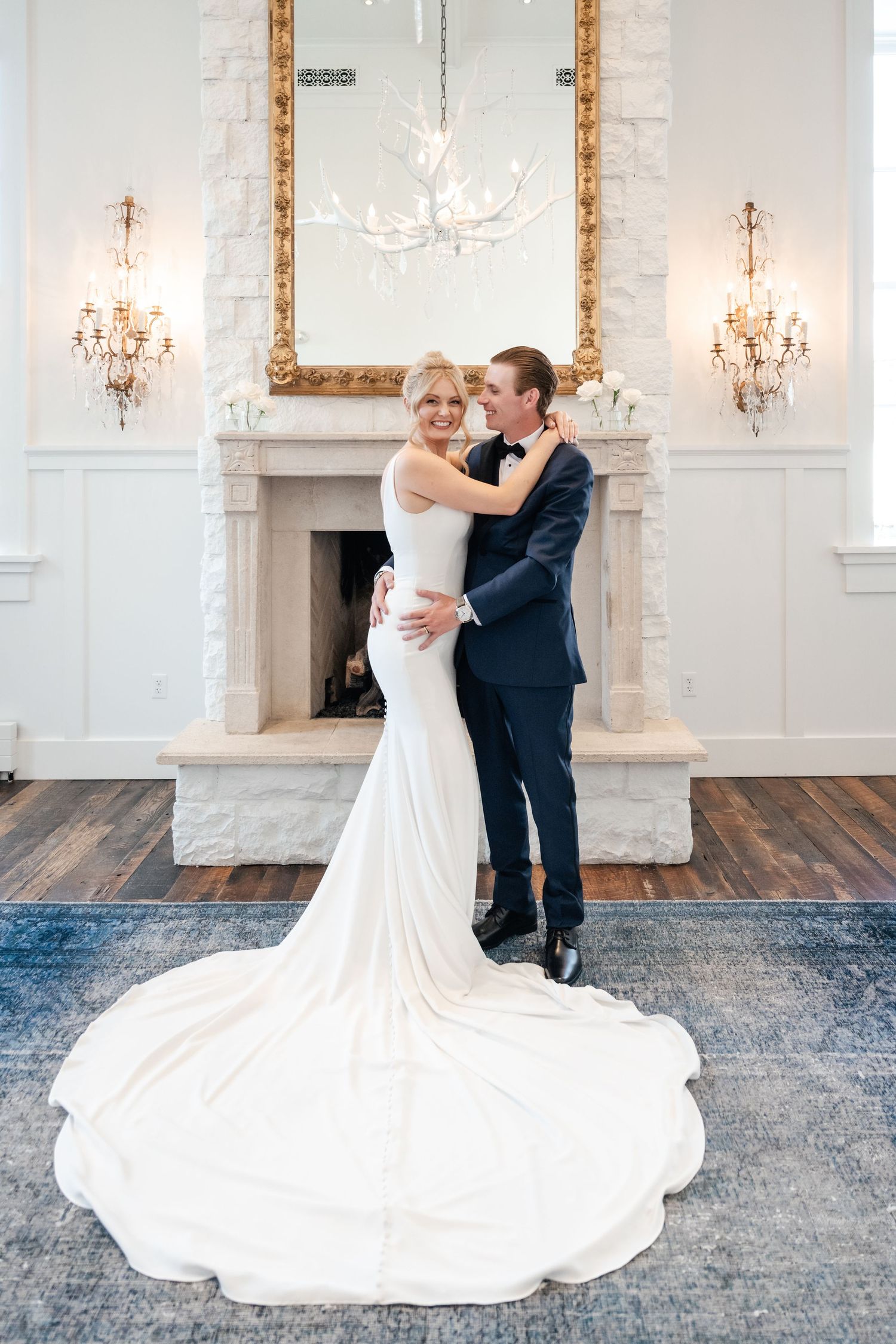 A couple sharing a romantic dance moment in a bright ballroom with crystal chandeliers.