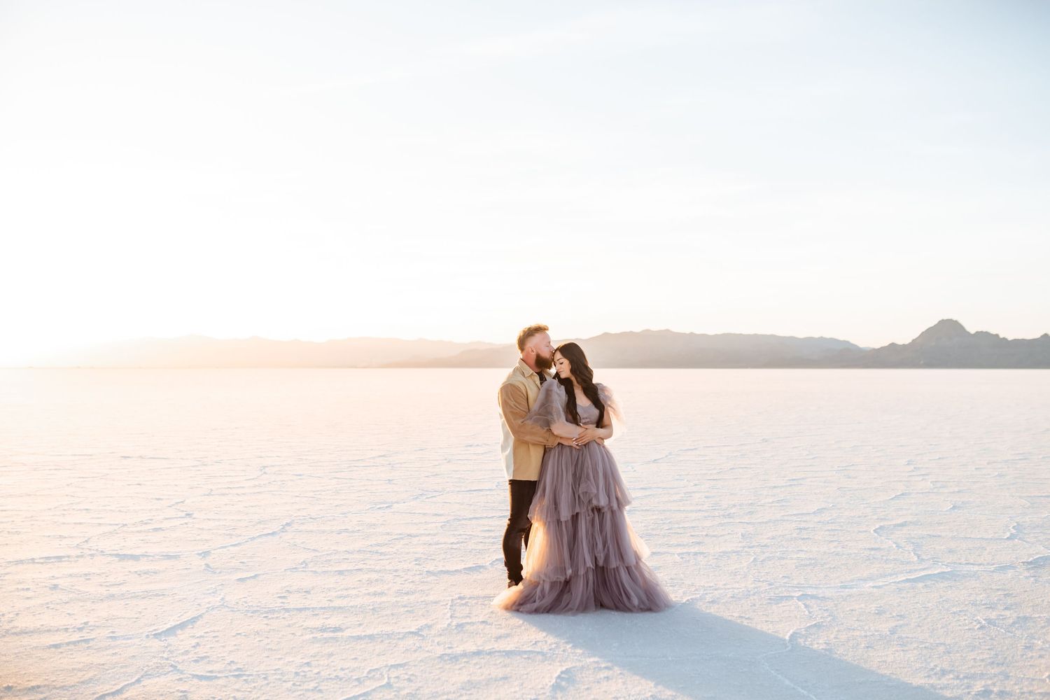 Couple hold each other during Salt Flats photos by Utah couples photographer during sunset