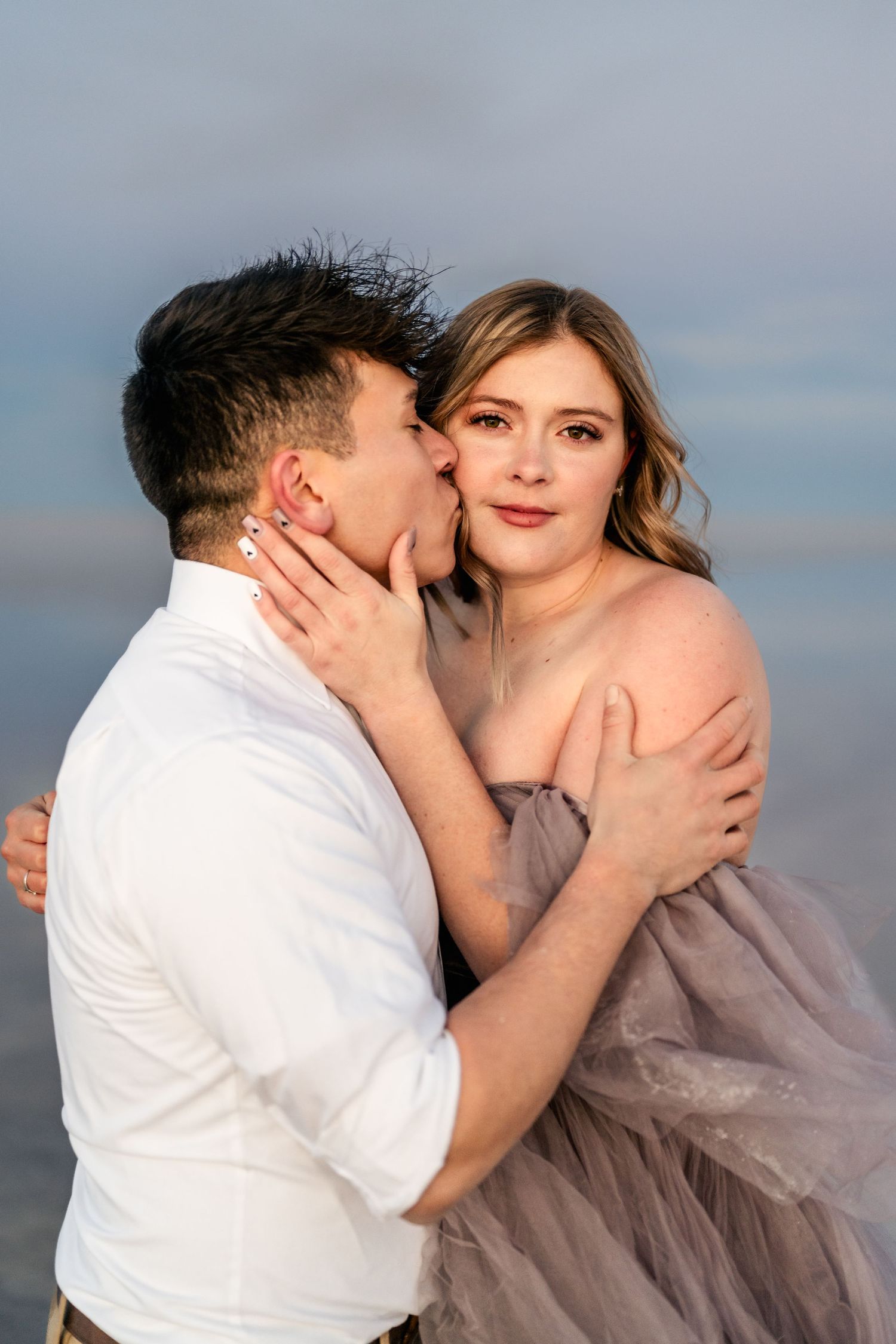 A tender embrace between the couple, illuminated by the soft blue light of blue hour at the Salt Flats.