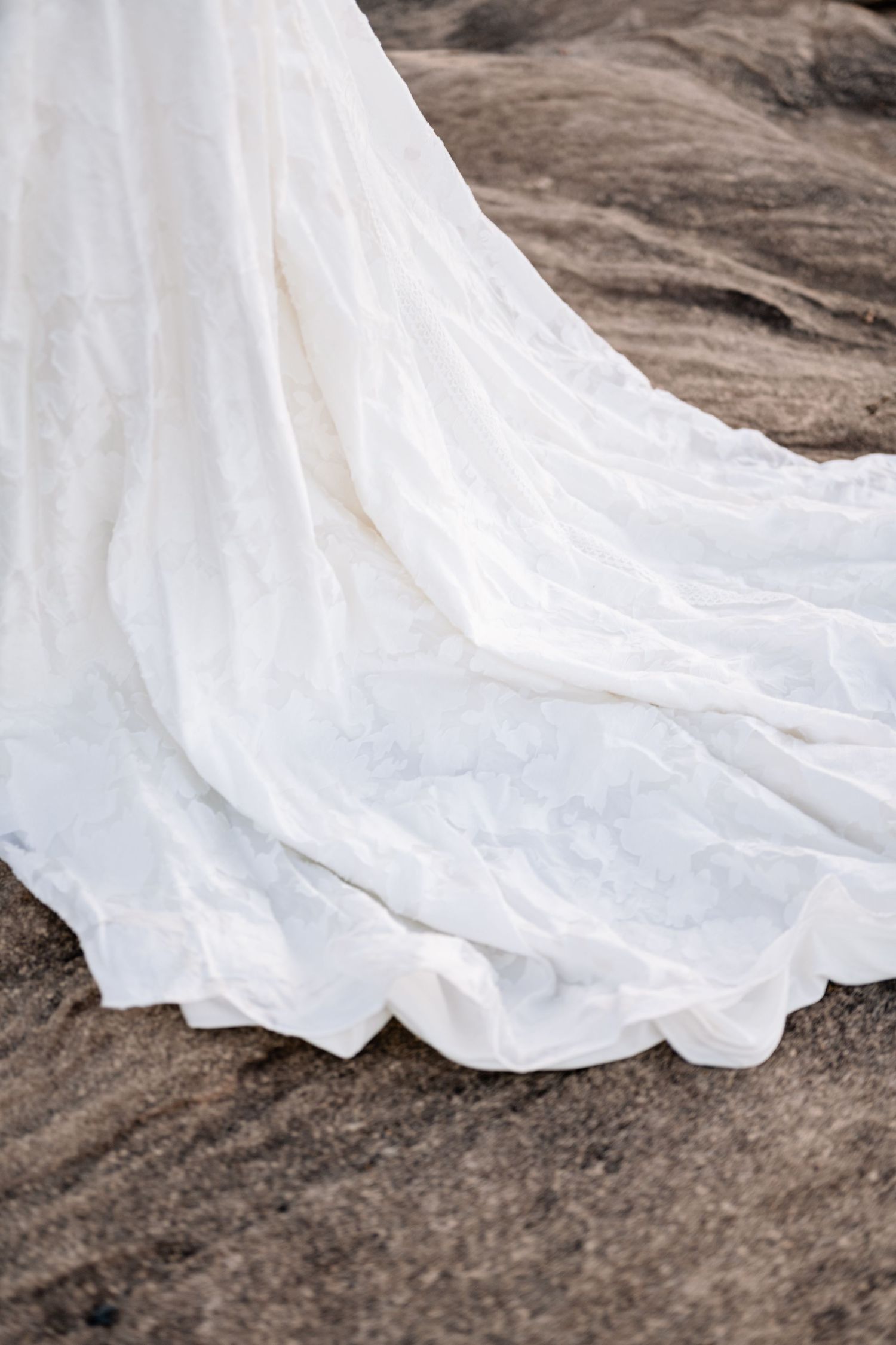 Bridal dress detail shot of the train against the desert red rock.