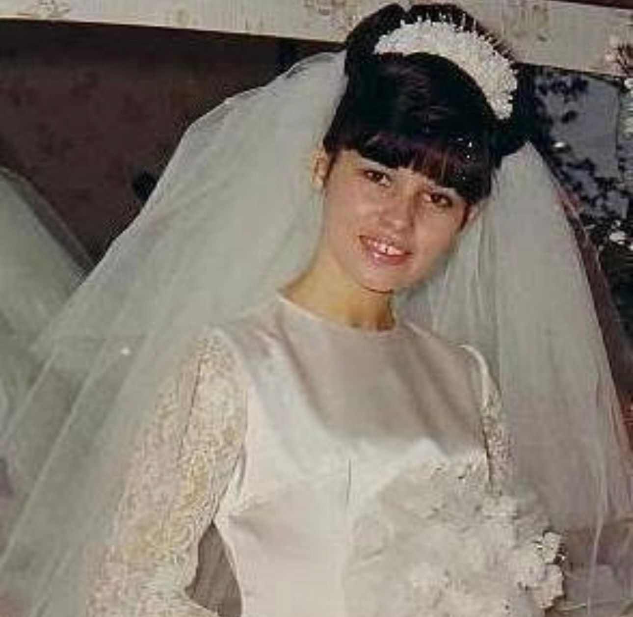 A bride wearing a traditional white wedding dress and veil poses for a series of photos with a joyful expression.