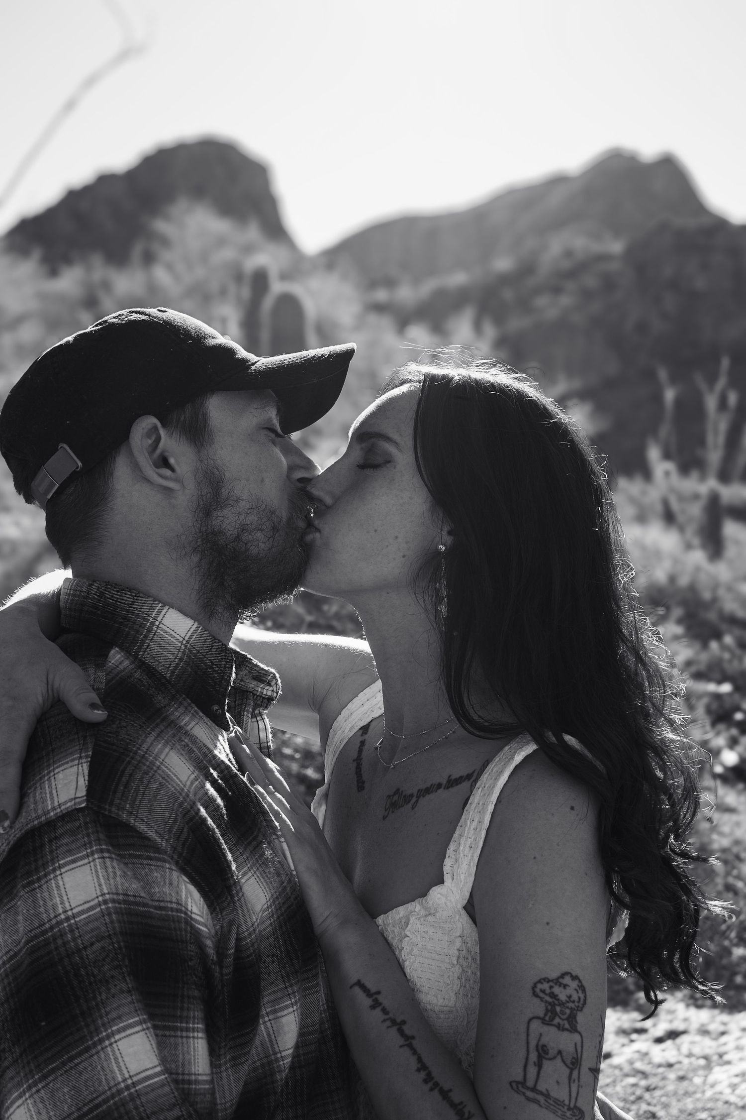 Romantic black and white portrait of couple sharing tender moment outdoors.