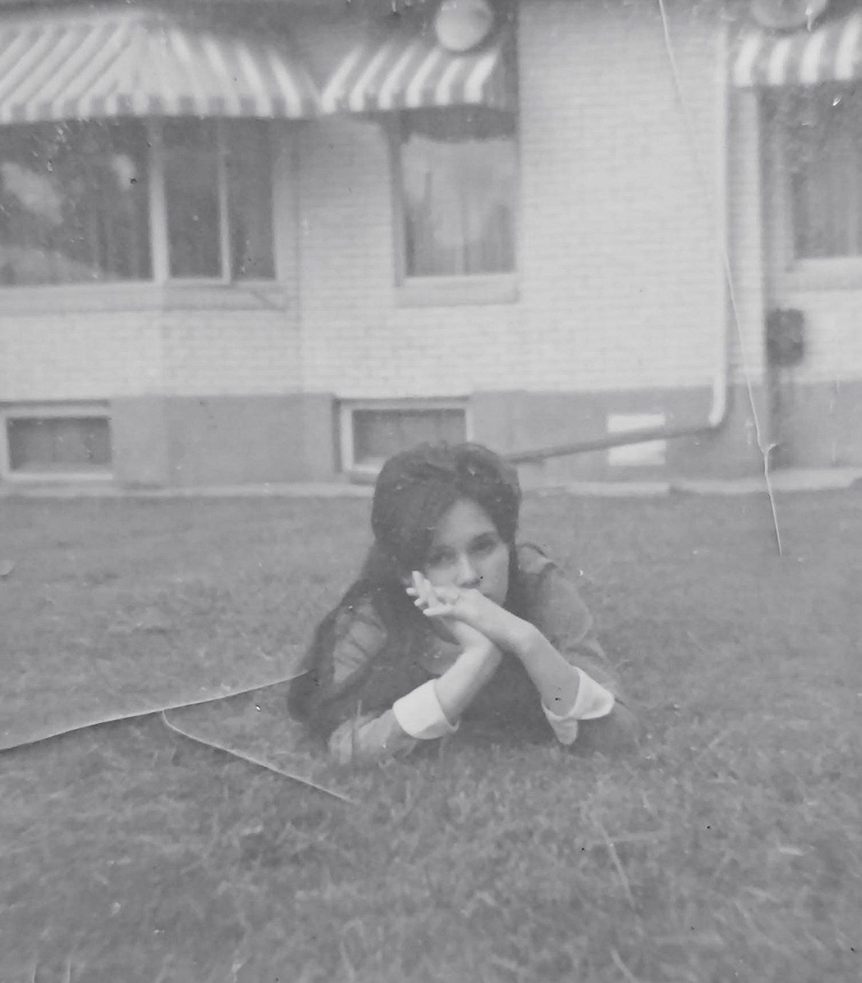 A sequence of black and white photographs showing someone rolling down a grassy hill.