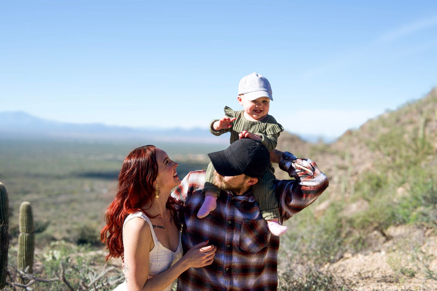 A couple shares tender moments against a desert mountain landscape backdrop.