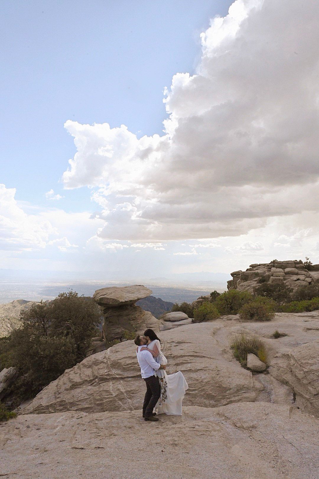 A dramatic desert landscape with rocky outcrops and cloudy skies.