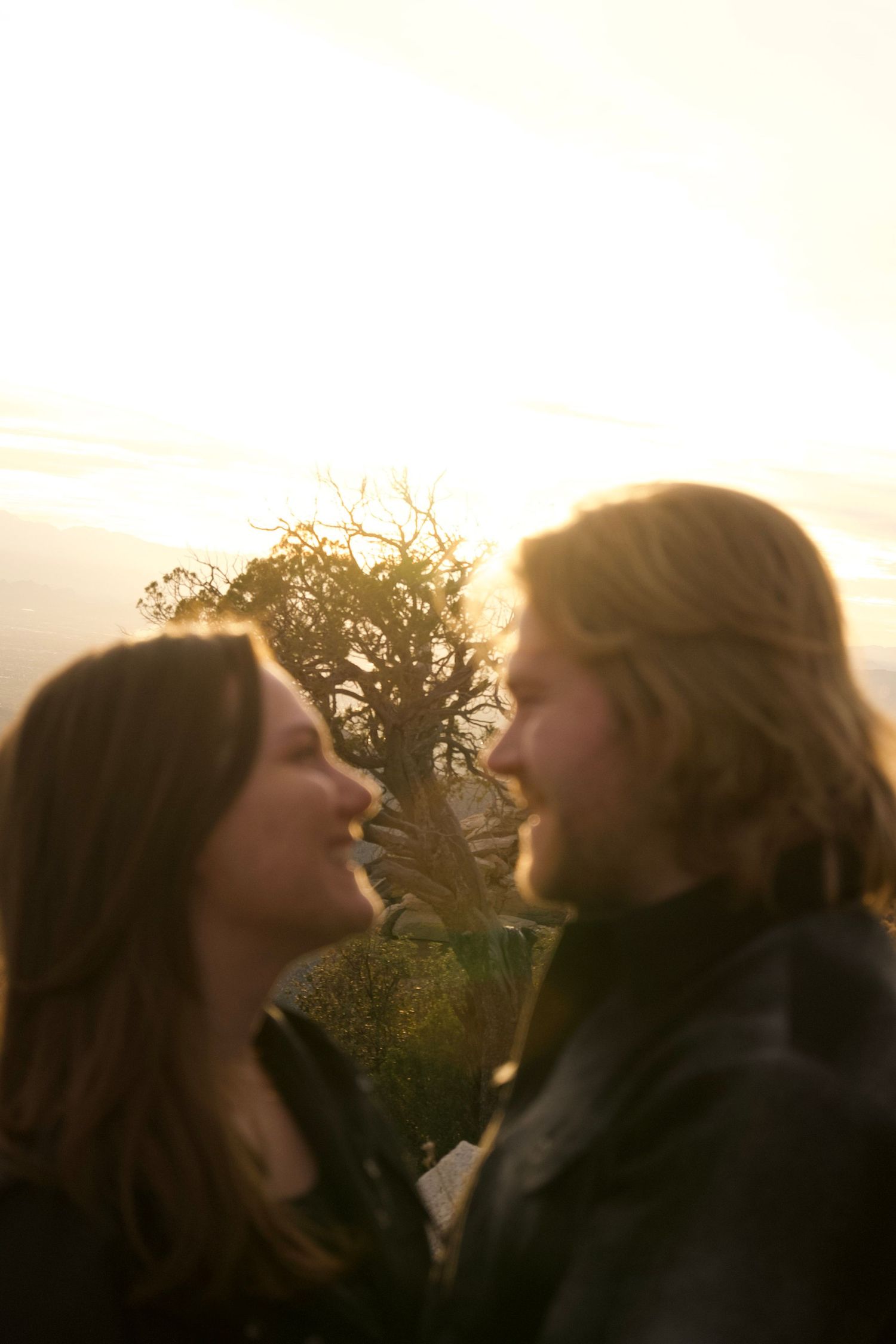A romantic sunset silhouette shows two people sharing an intimate moment against a glowing sky.