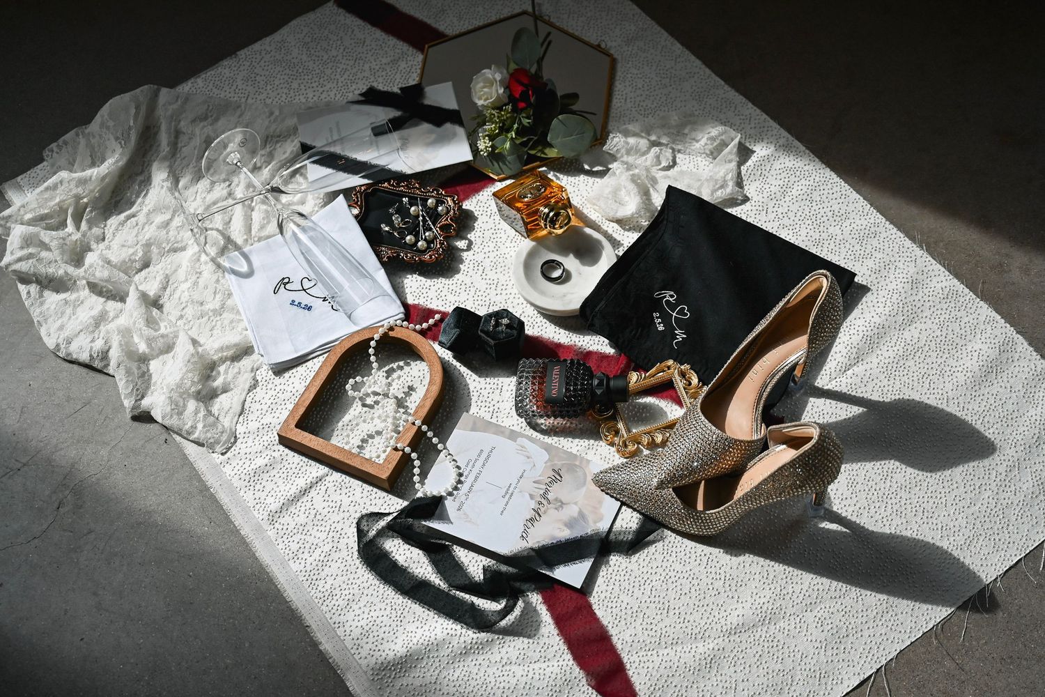 A collection of high heeled shoes arranged on white paper with natural lighting and shadows.