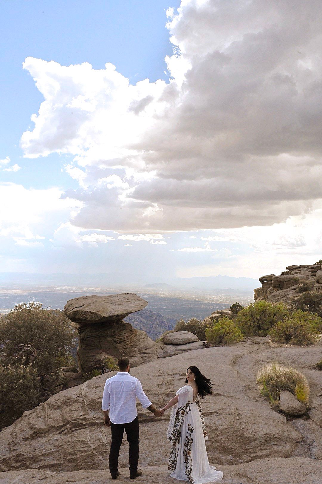 A dramatic mountain vista with rocky outcrops and cloudy skies in the background.