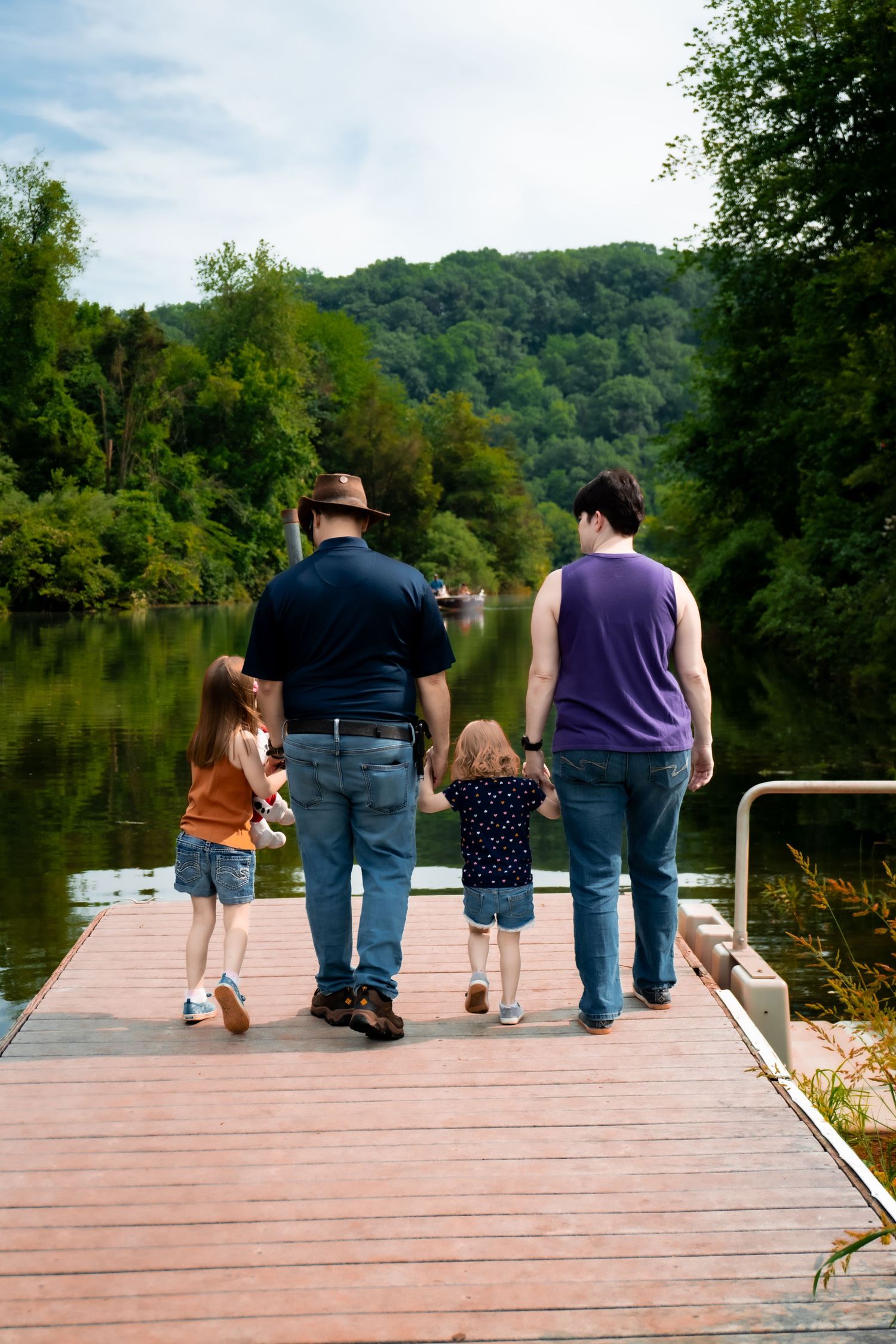 A family enjoying a peaceful moment together on a wooden dock overlooking tranquil waters.