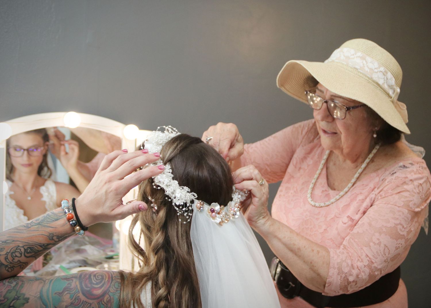 Behind the scenes wedding preparation with floral crown being placed on bride.