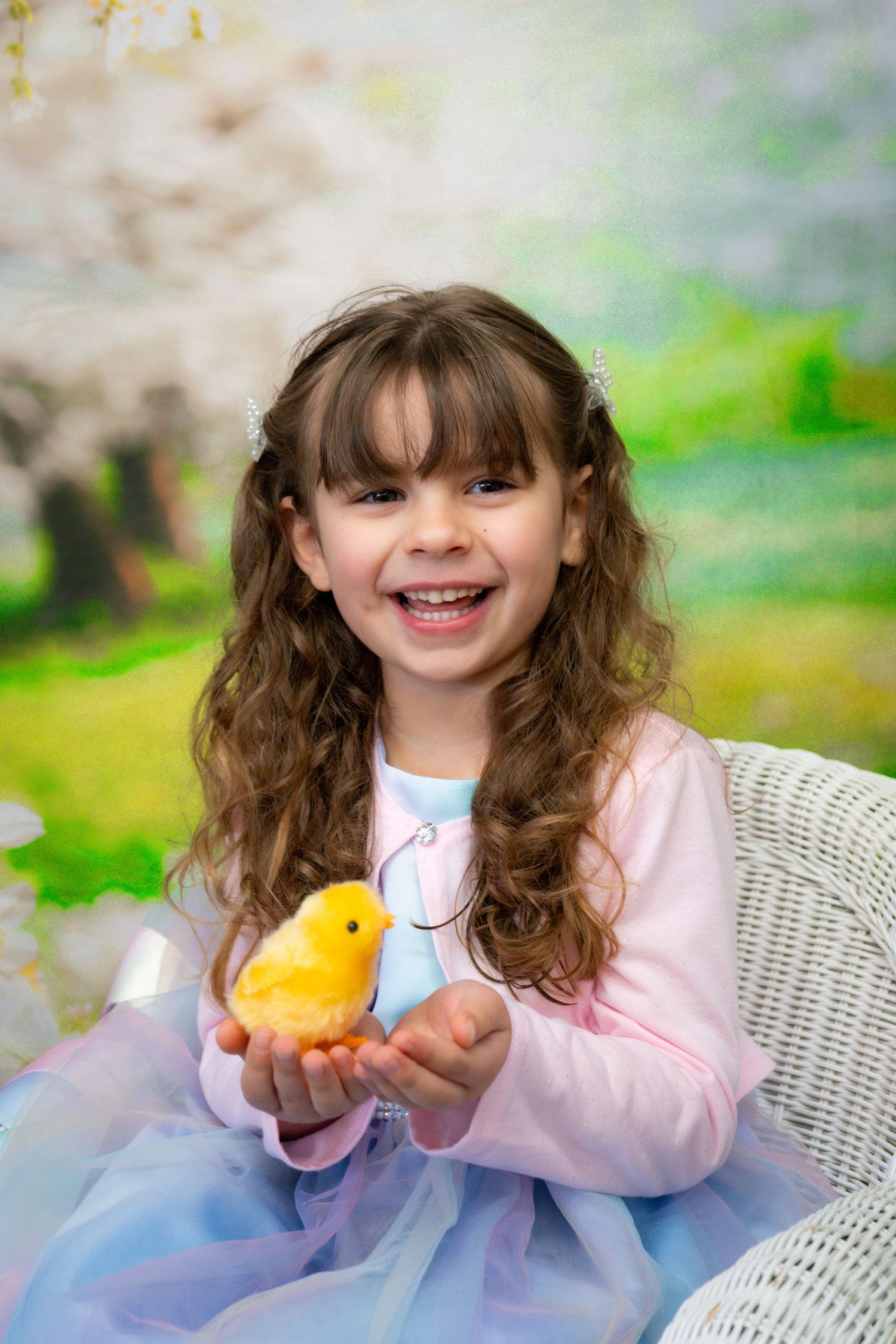 A spring portrait with a yellow baby chick and dreamy pastel background.