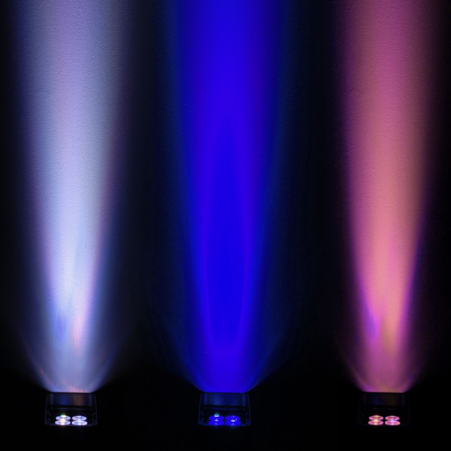 Three vibrant uplights creating beams of white, blue and pink light against dark background.