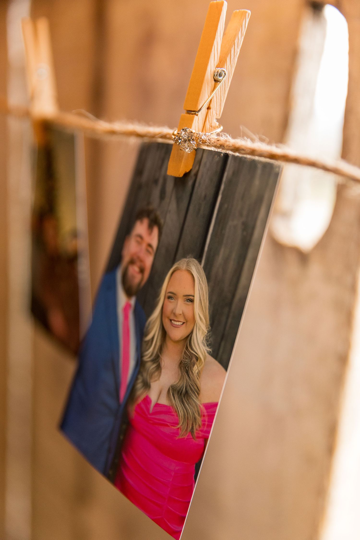 A photograph clipped to a string with a clothespin shows a couple in formal attire.