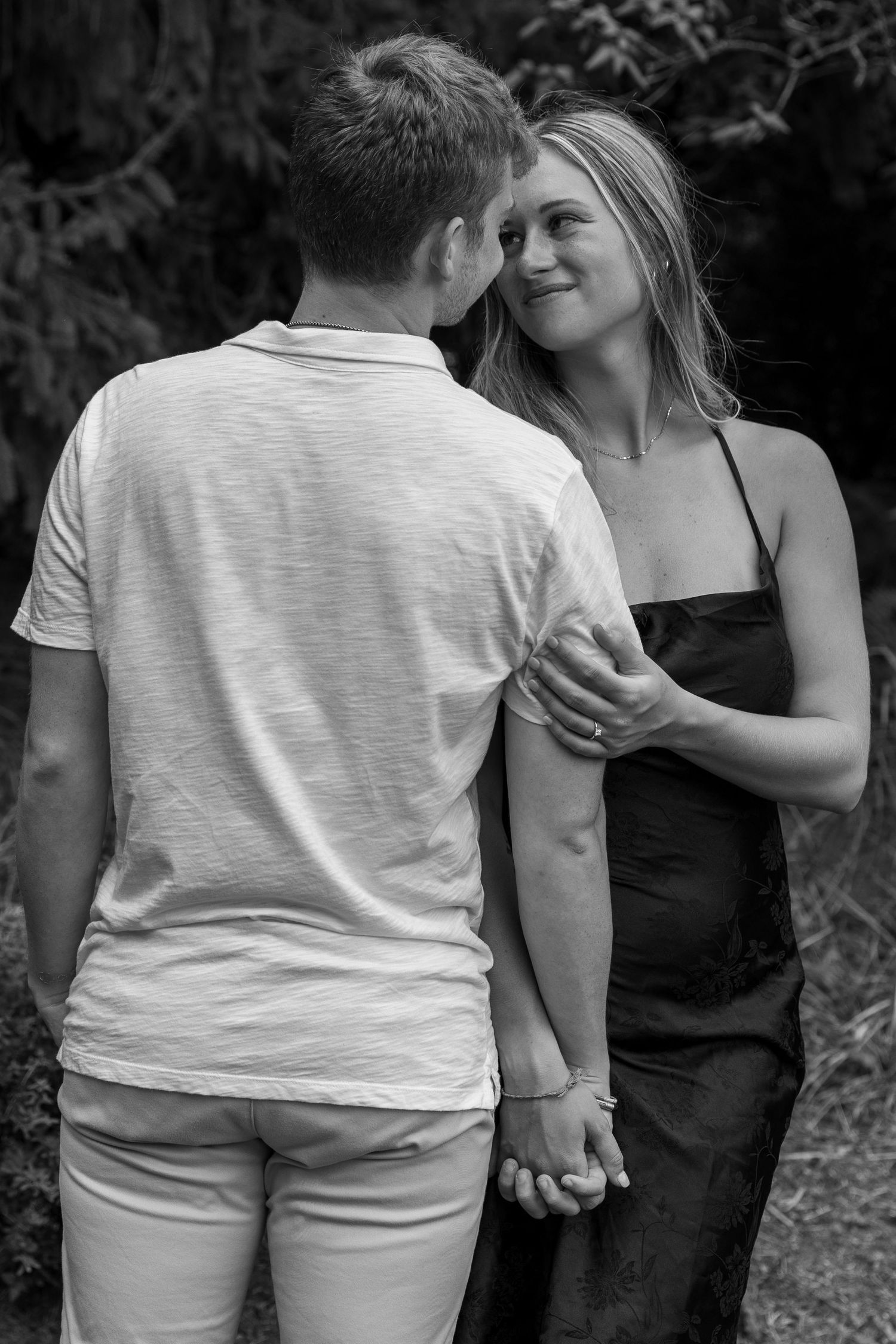 Black and white portrait capturing an intimate moment between a couple outdoors.